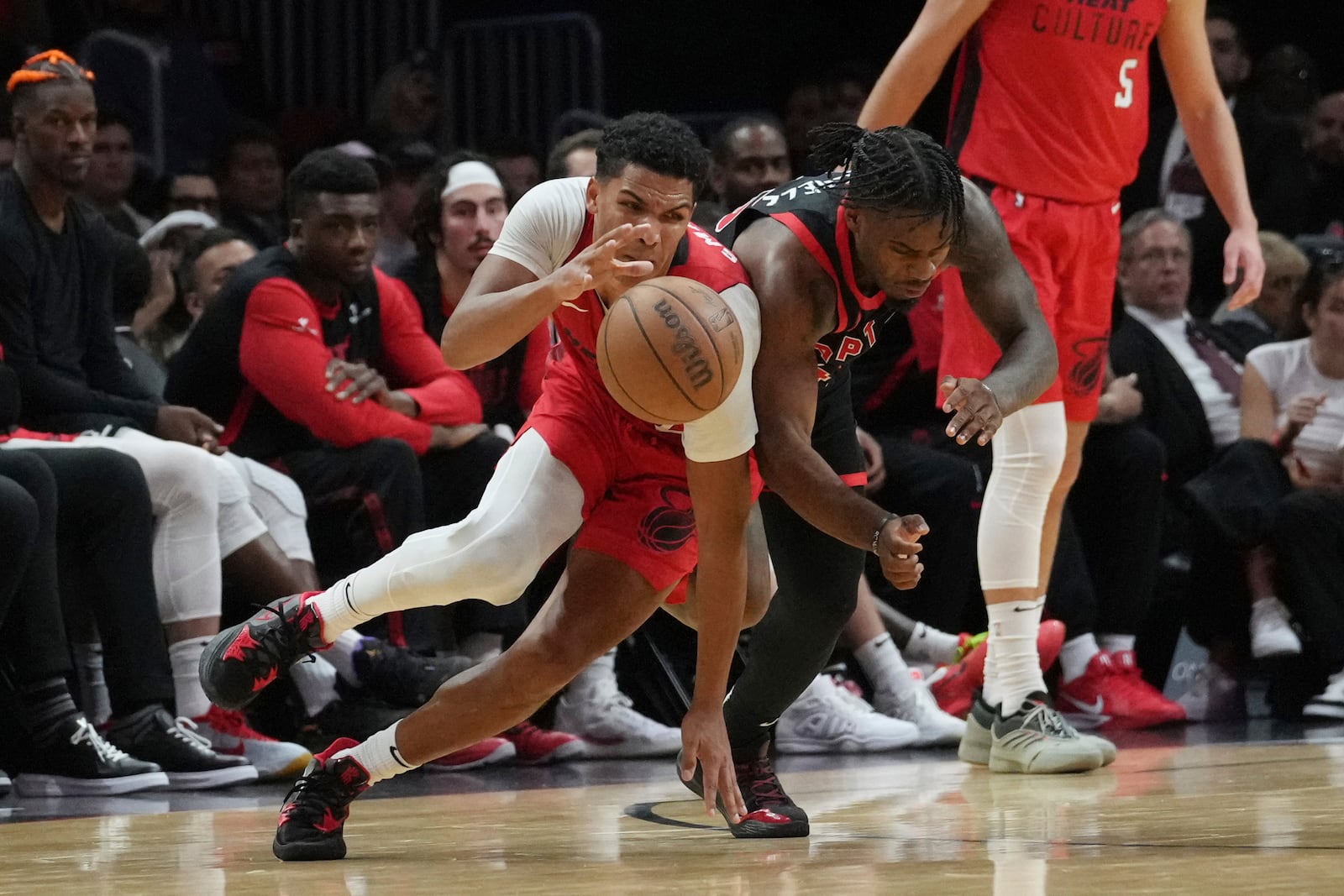 Toronto Raptors guard Davion Mitchell (45) fouls Miami Heat guard Dru Smith (12) during the second half of an NBA basketball game, Thursday, Dec. 12, 2024, in Miami. (AP Photo/Marta Lavandier)