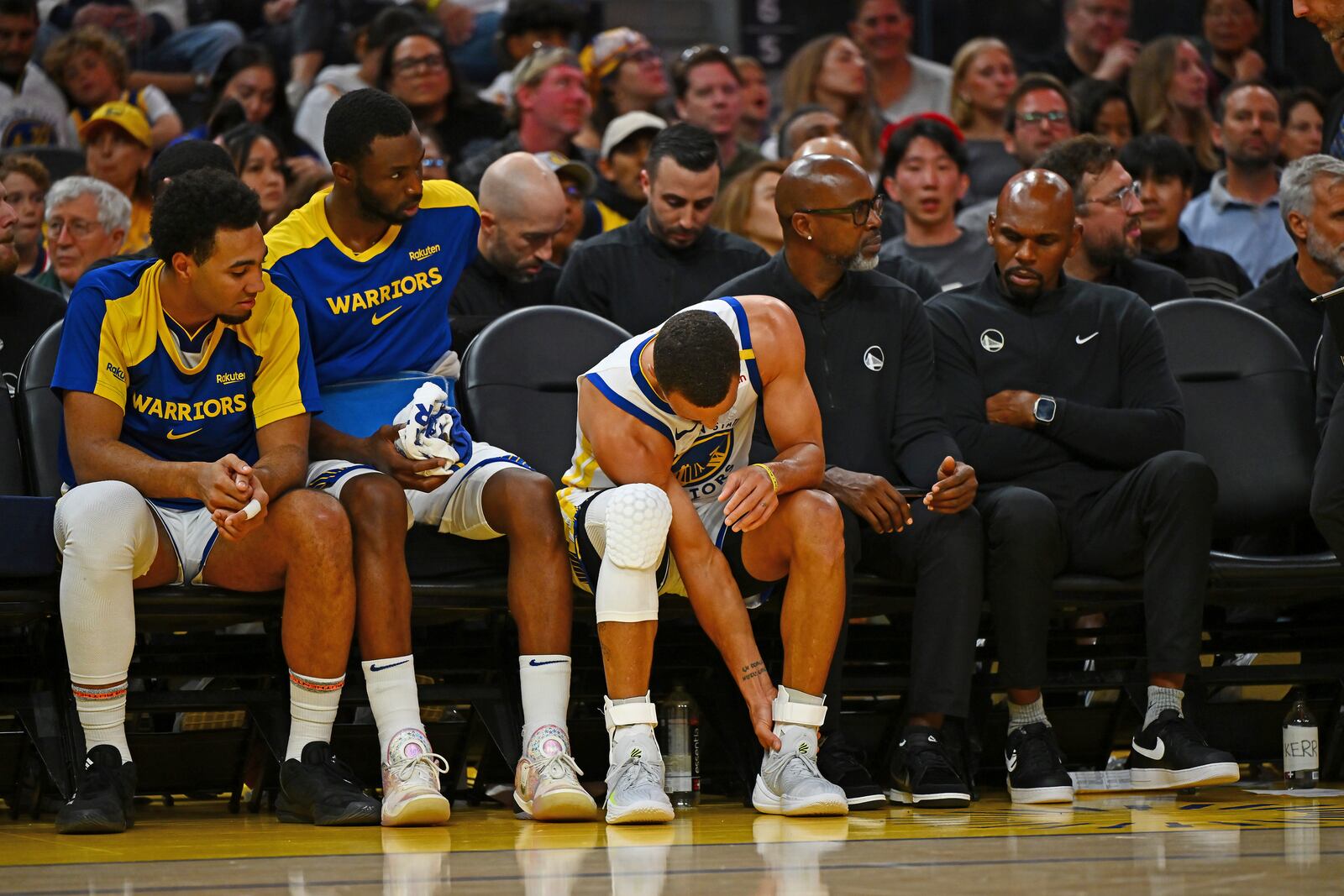 Golden State Warriors' Stephen Curry, center, holds his left ankle after sustaining an injury in the third quarter of an NBA basketball game against the Los Angeles Clippers in San Francisco, Sunday, Oct. 27, 2024. (Jose Carlos Fajardo/Bay Area News Group via AP)