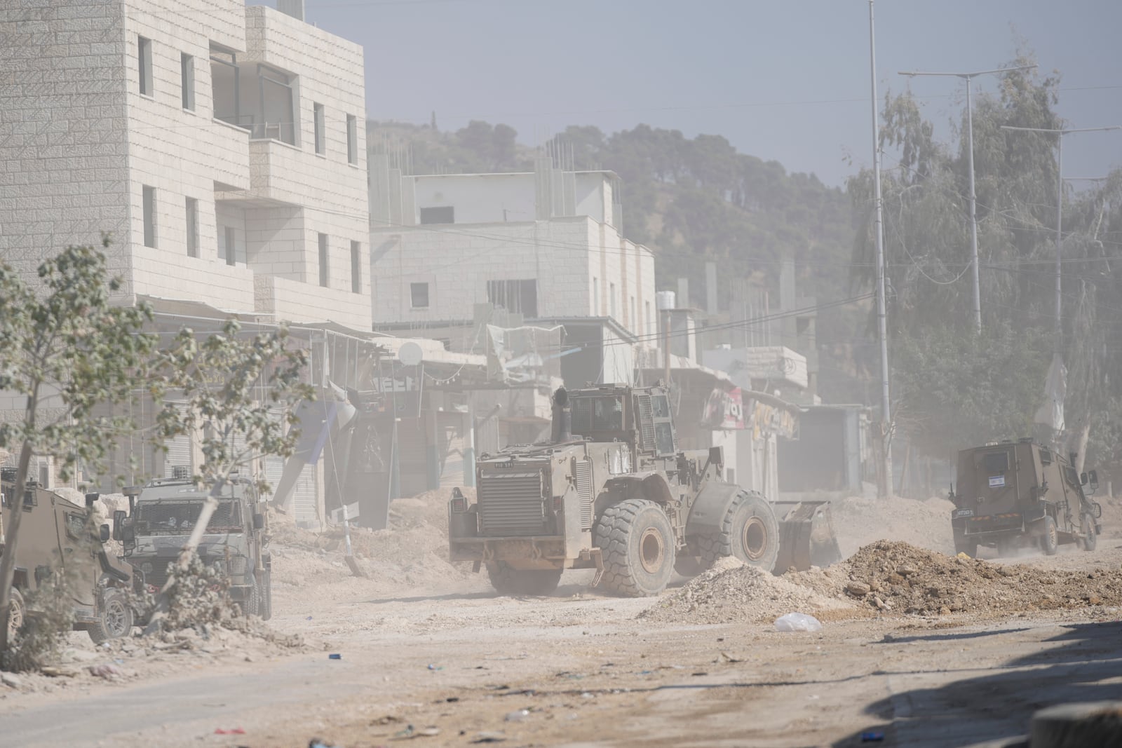 An Israeli army bulldozer operates at the parameter of the Nur Shams refugee camp during the ongoing army operation, after the Palestinian Health Ministry said two Palestinians were killed in an Israeli strike and a third by Israeli gunfire, in the West Bank city of Tulkarem, Thursday, Oct. 31, 2024. (AP Photo/Nasser Nasser)