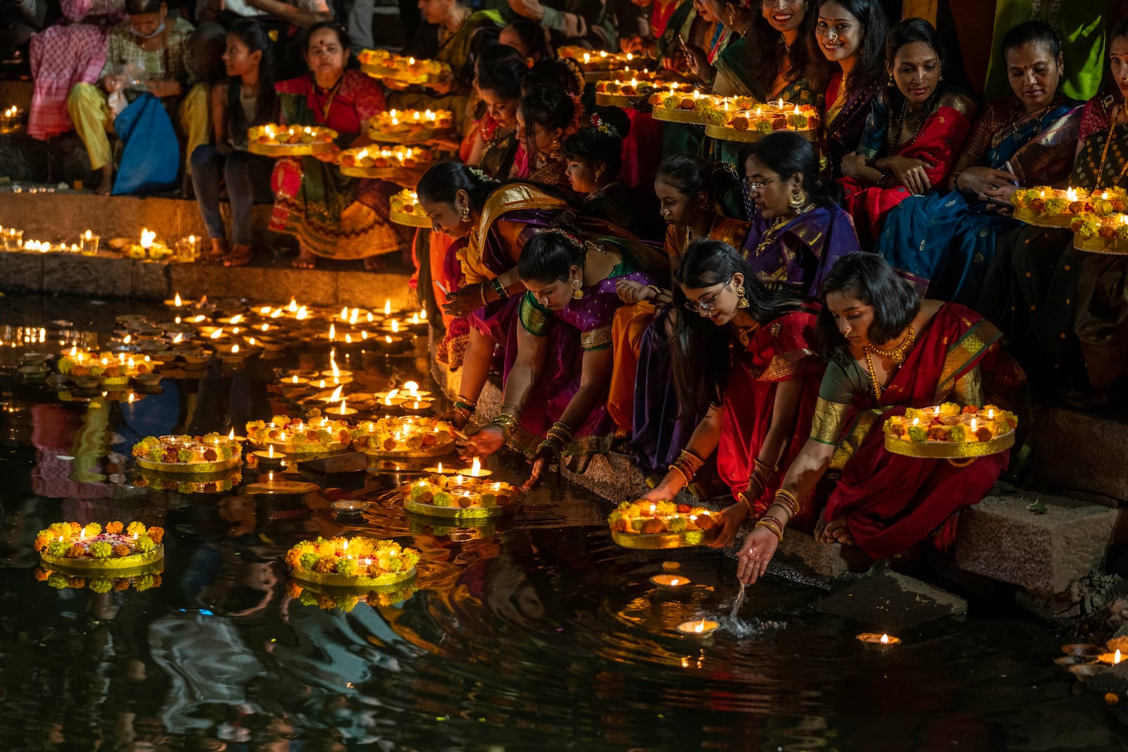 FILE- Hindu women light oil lamps at the Banganga pond as they celebrate Dev Diwali festival in Mumbai, India, Nov. 7, 2022. (AP Photo/Rafiq Maqbool, File)