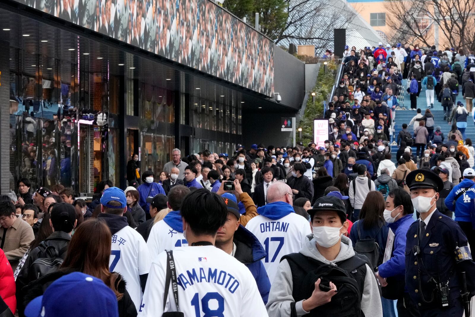 People wait in queue to enter an official shop before an MLB Japan Series baseball game between the Los Angeles Dodgers and the Chicago Cubs at Tokyo Dome, in Tokyo, Tuesday, March 18, 2025. (AP Photo/Shuji Kajiyama)