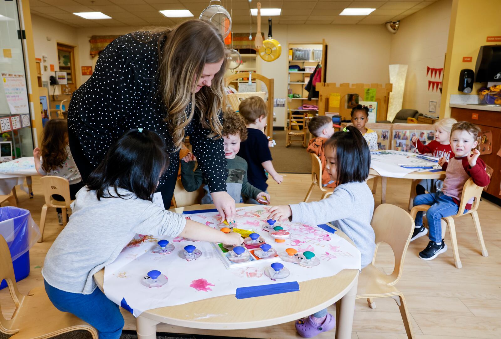 Childcare Director Lauren Kolks helps students with a craft project in the pre-k class at Mini University, a child development center on the Miami  University campus,  Thursday, April 6, 2023 in Oxford. NICK GRAHAM/STAFF