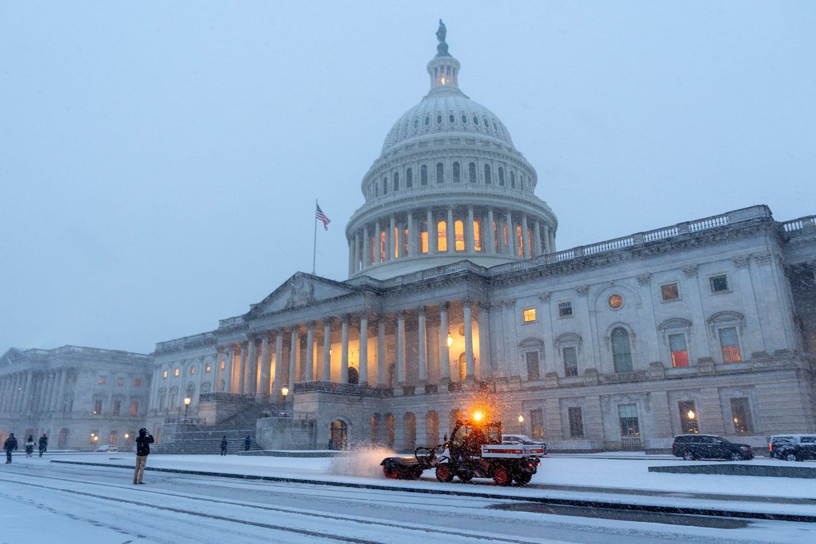 A small snowplow removes falling snow from walkways at the Capitol, Tuesday, Feb. 11, 2025, as dusk begins to fall during a snowstorm in Washington. (AP Photo/Jacquelyn Martin)