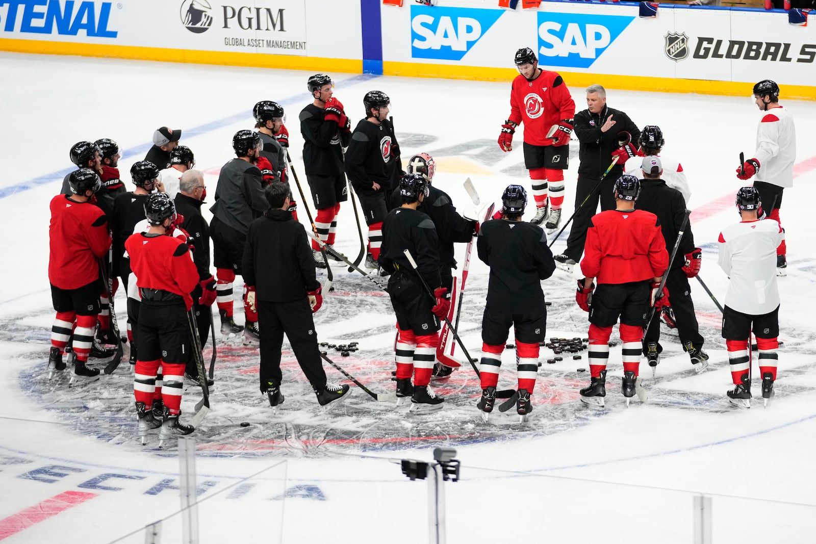 New Jersey Devils' listen to their coaches during a practice session, a day before their NHL hockey game against Buffalo Sabres, in Prague, Czech Republic, Thursday, Oct. 3, 2024. (AP Photo/Petr David Josek)