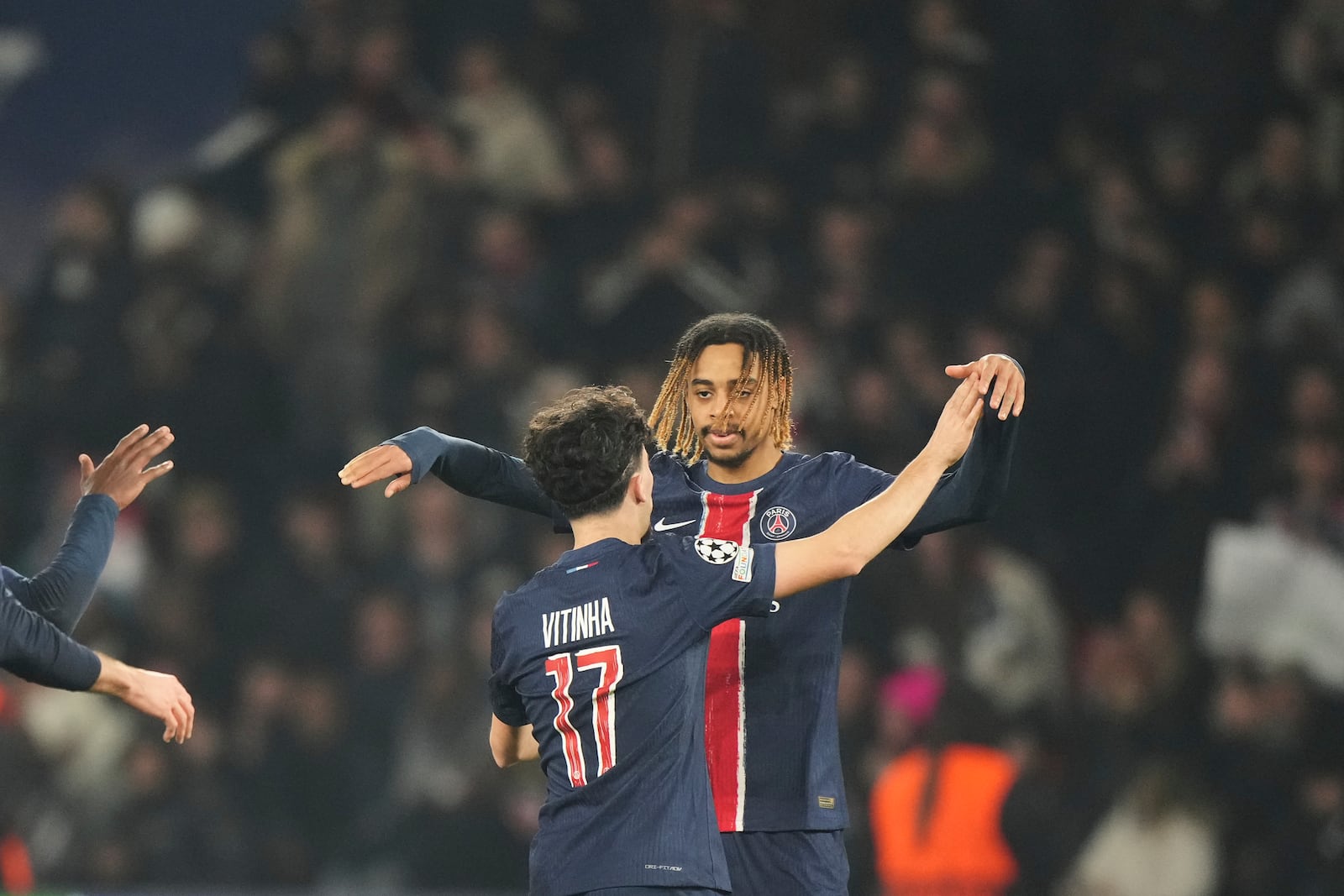 PSG's Vitinha , left, celebrates with teammate PSG's Bradley Barcola after scoring his side's third goal during the Champions League playoff second leg soccer match between Paris Saint-Germain and Brest at the Parc des Princes in Paris, Wednesday, Feb. 19, 2025. (AP Photo/Michel Euler)