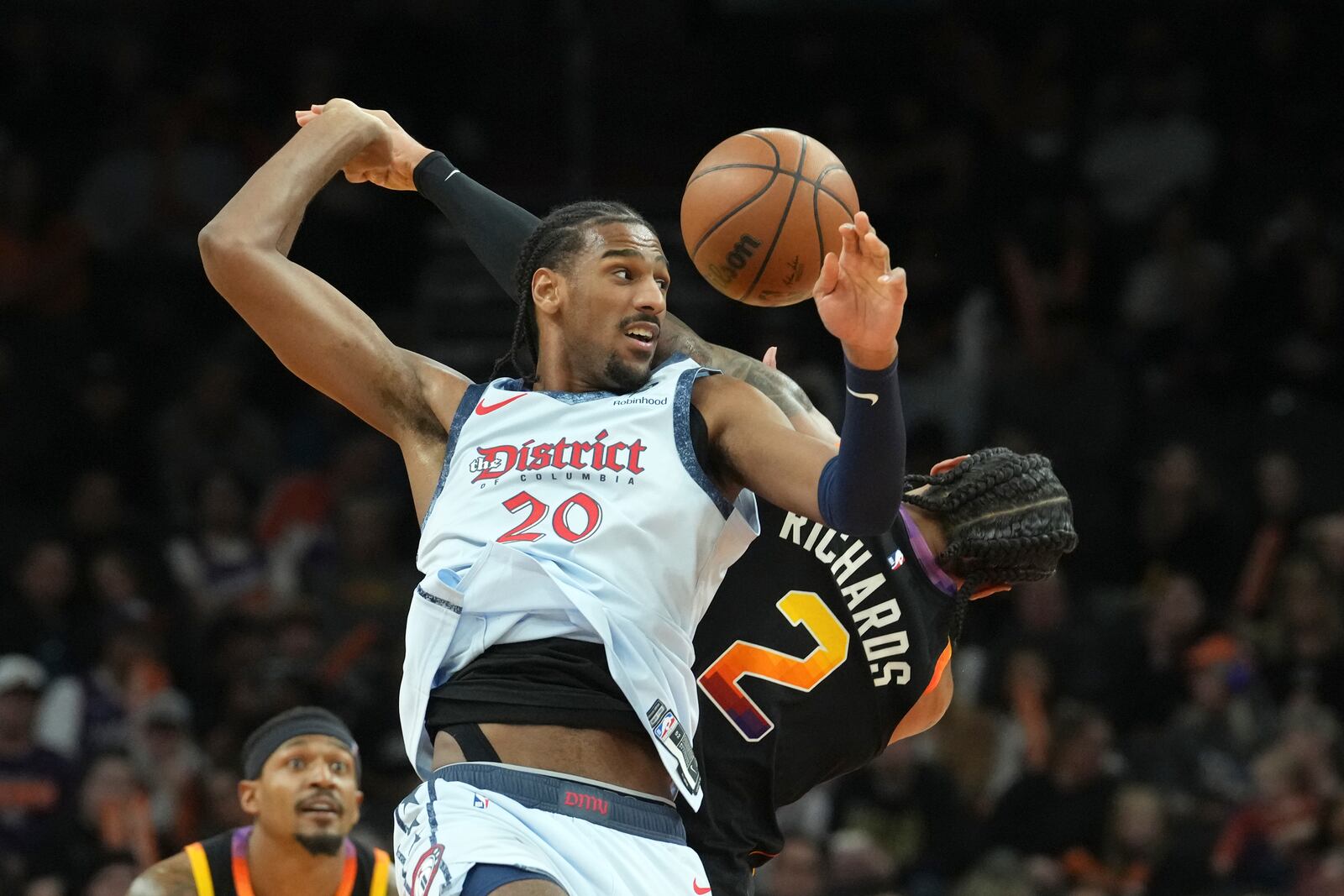 Washington Wizards forward Alex Sarr (20) becomes entangled with Phoenix Suns center Nick Richards (2) on a jump ball during the second half of an NBA basketball game Saturday, Jan. 25, 2025, in Phoenix. (AP Photo/Ross D. Franklin)