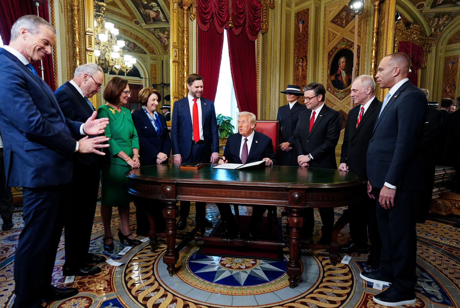 President Donald Trump, center, takes part in a signing ceremony in the President's Room after the 60th Presidential Inauguration, Monday, Jan. 20, 2025, at the U.S. Capitol in Washington. Surrounding the president are, from left, Senate Majority Leader Sen. John Thune, R-S.D.; Senate Minority Leader Chuck Schumer, D-N.Y.; Sen. Deb Fischer, R-Neb.; Sen. Amy Klobuchar, D-Minn.; Vice President JD Vance; first lady Melania Trump; House Speaker Mike Johnson, R-La.; House Majority Leader Steve Scalise, R-La.; and House Minority Leader Hakeem Jeffries, D-N.Y. (Melina Mara/The Washington Post via AP, Pool)