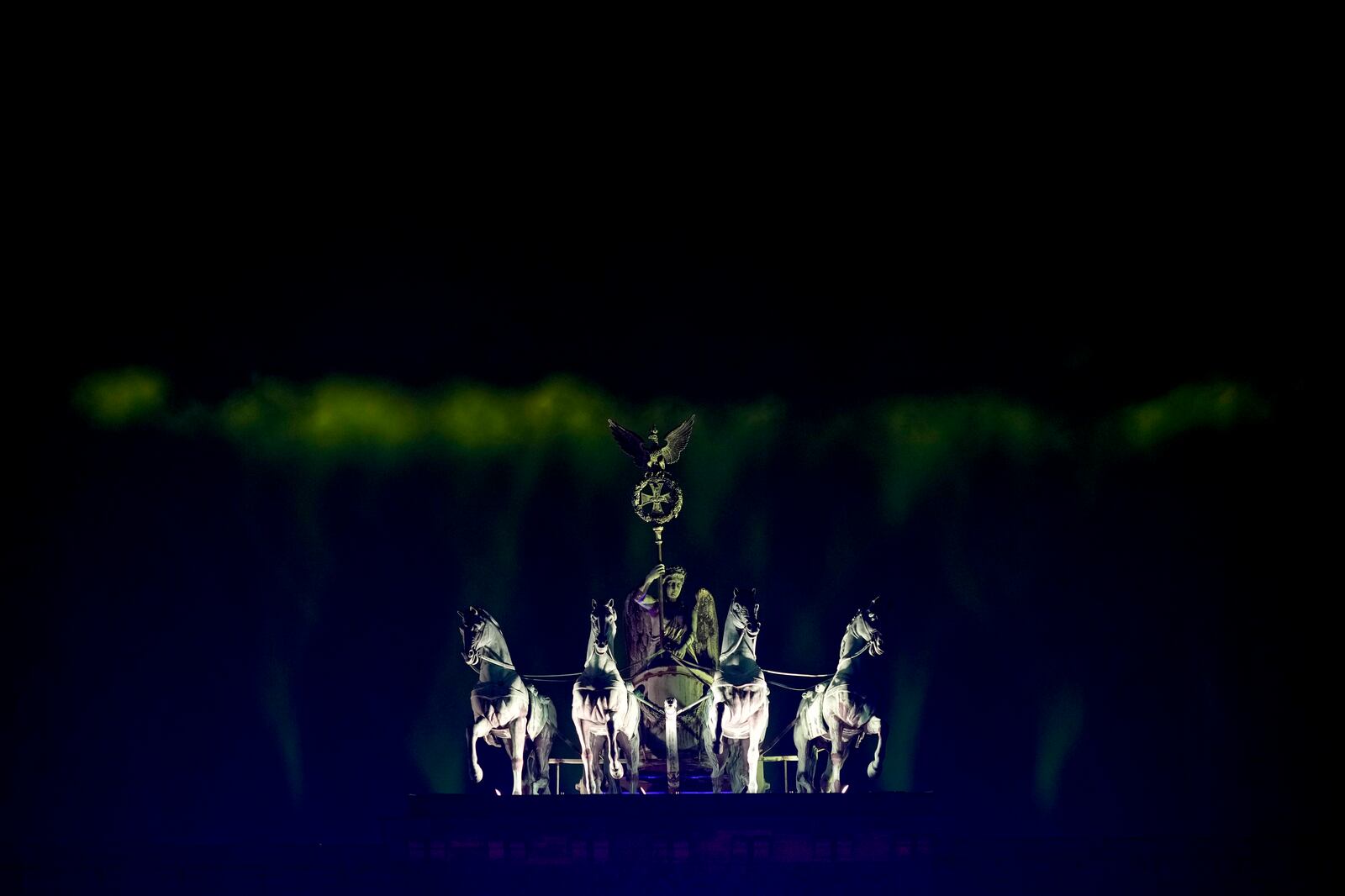 A projection lights the sky above the Brandenburg Gate as musicians play on the stage during the concert for freedom for the 35th anniversary of the fall of the Berlin Wall, in Berlin, Germany, Saturday, Nov. 9, 2024. (AP Photo/Ebrahim Noroozi)