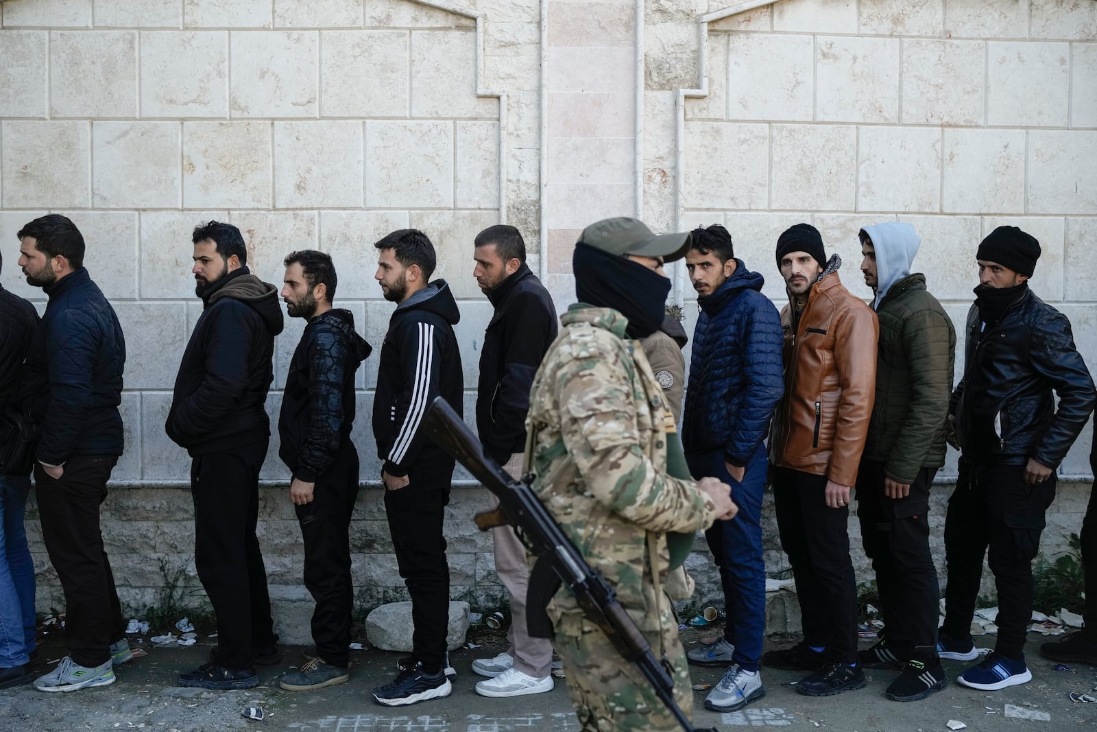 FILE - Members from Bashar Assad's Syrian army period line up to register with Syrian rebels as part of a "identification and reconciliation process" at a army compound in Latakia, Syria, Tuesday, Dec. 17, 2024. (AP Photo/Leo Correa, File)