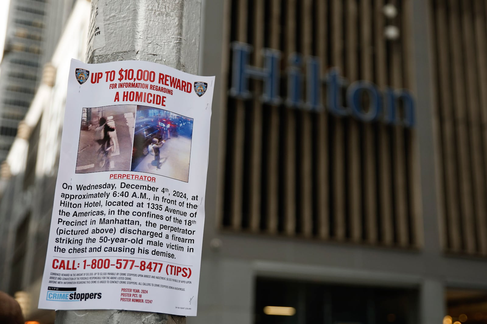 A reward poster hangs on a light pole outside the Hilton Hotel in midtown Manhattan where Brian Thompson, the CEO of UnitedHealthcare, was fatally shot ,Wednesday, Dec. 4, 2024, in New York. (AP Photo/Stefan Jeremiah)