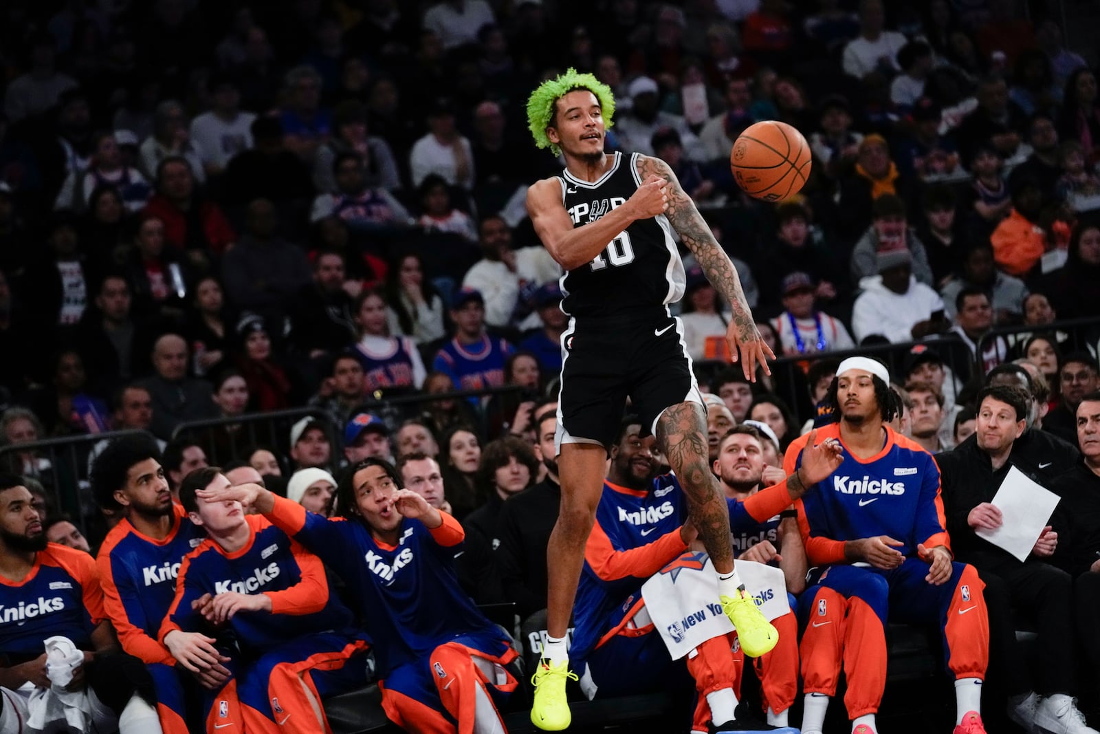 San Antonio Spurs' Jeremy Sochan throws the ball back in-bounds as he falls into the New York Knicks bench during the first half of an NBA basketball game, Wednesday, Dec. 25, 2024, in New York. (AP Photo/Seth Wenig)