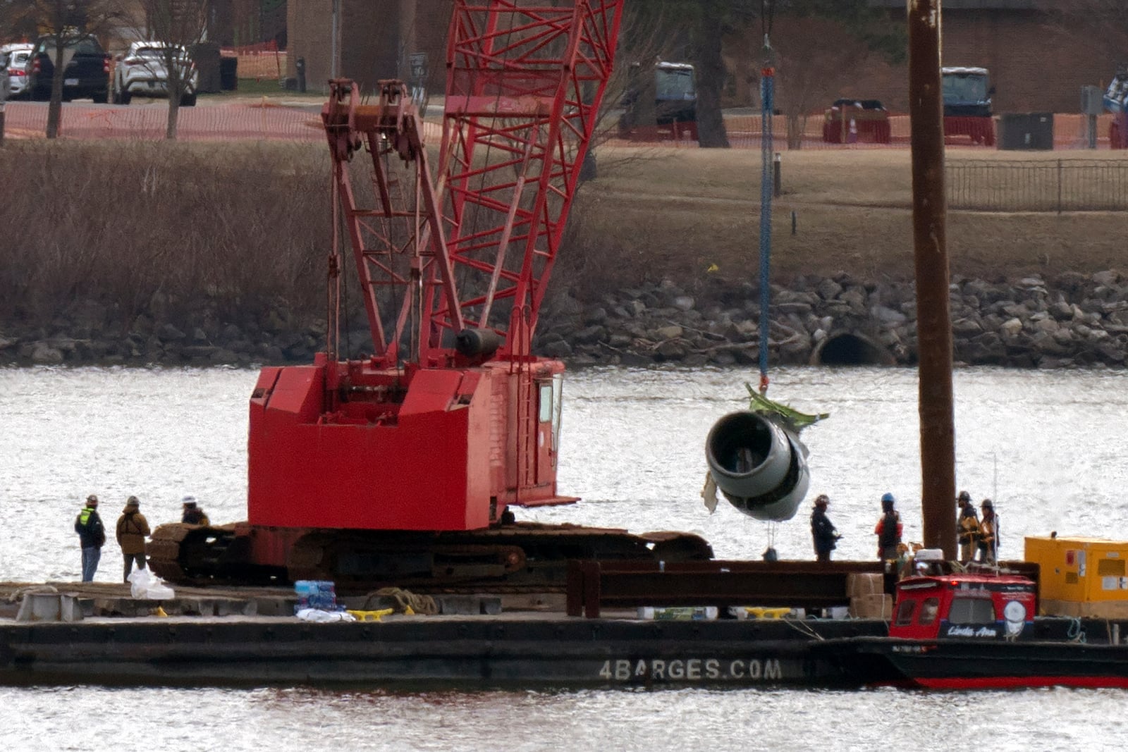 Rescue and salvage crews pull up a plane engine as cranes work near the wreckage of an American Airlines jet in the Potomac River from Ronald Reagan Washington National Airport, Monday, Feb. 3, 2025, in Arlington, Va. (AP Photo/Jose Luis Magana)