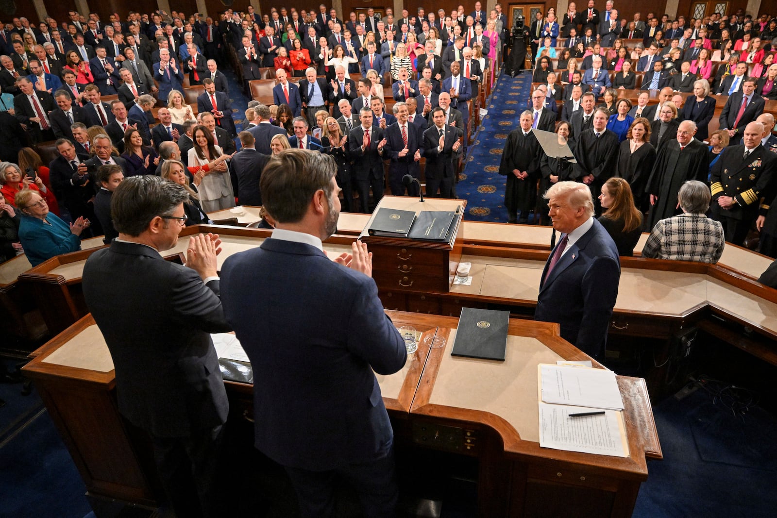 Vice President JD Vance, center, and Speaker of the House Mike Johnson, R-La., left, clap as President Donald Trump, right, arrives to address a joint session of Congress at the Capitol in Washington, Tuesday, March 4, 2025. (Mandel Ngan/Pool Photo via AP)