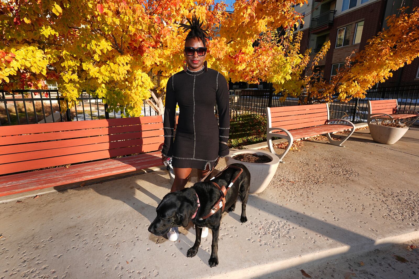 Amber Sherrard and her 10-year-old black Labrador Della are shown outside their home Friday, Nov. 15, 2024, in east Denver. (AP Photo/David Zalubowski)