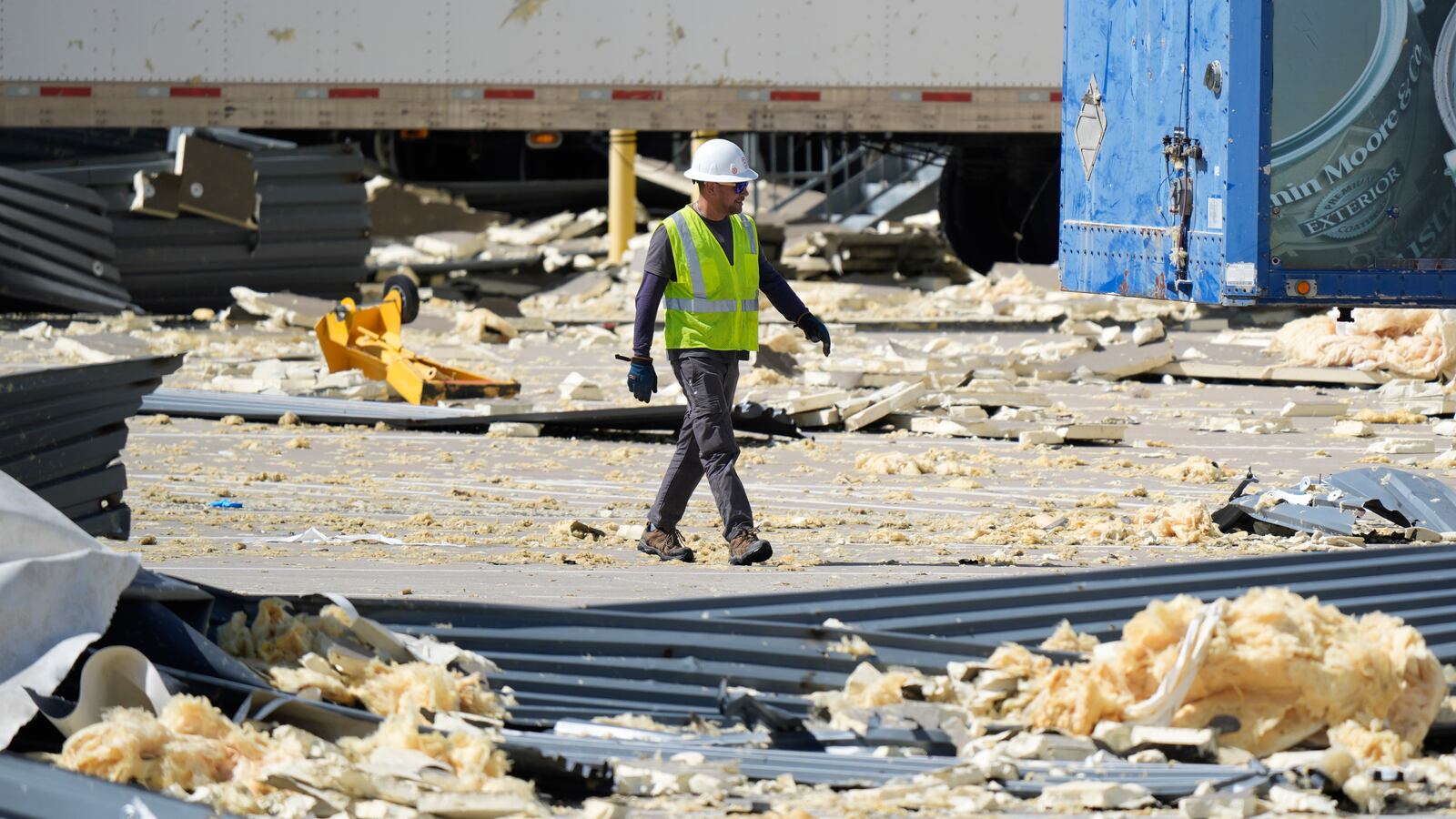 A worker walks through debris from a damaged warehouse after storms moved through Tuesday, March 4, 2025, in Lewisville, Texas. (AP Photo/LM Otero)