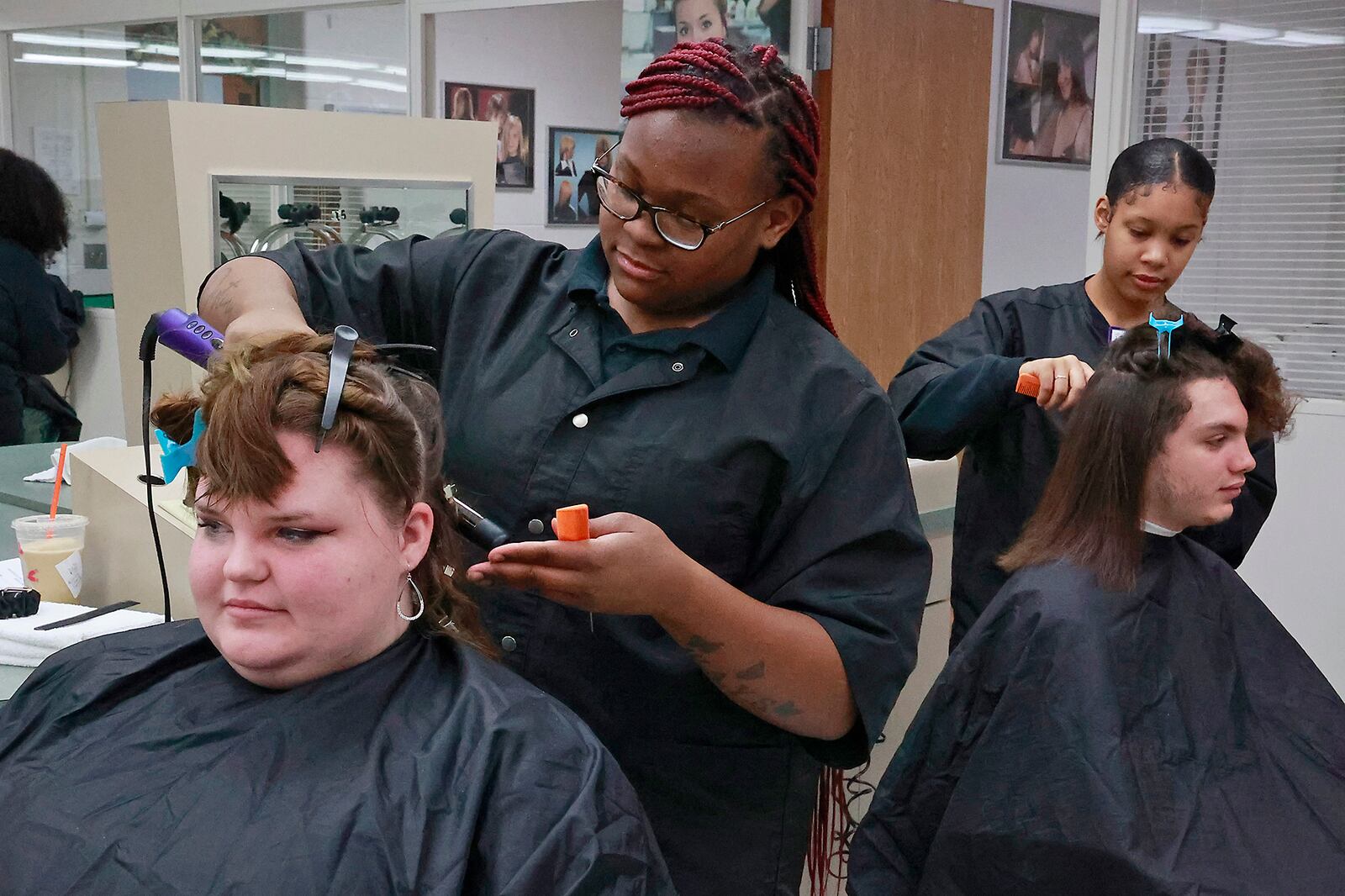 CTC students Eyriona Arnold, left, and Aireona Harris work on the hair of fellow students, Alexis Mitch and Ramzi Irvin, during the open Spa in the Cosmetology Department on Friday, Jan. 13, 2023. BILL LACKEY/STAFF