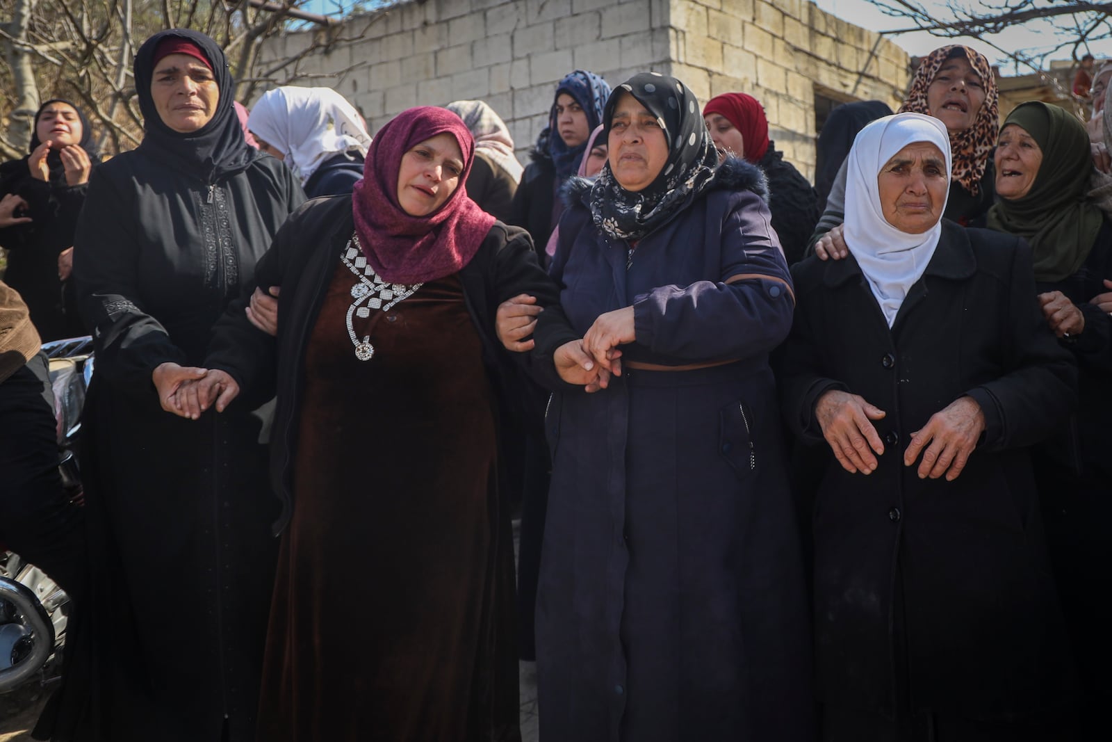 Relatives and neighbours mourn during the funeral procession for four Syrian security force members killed in clashes with loyalists of ousted President Bashar Assad in coastal Syria, in the village of Al-Janoudiya, west of Idlib, Saturday, March 8, 2025. (AP Photo/Omar Albam)