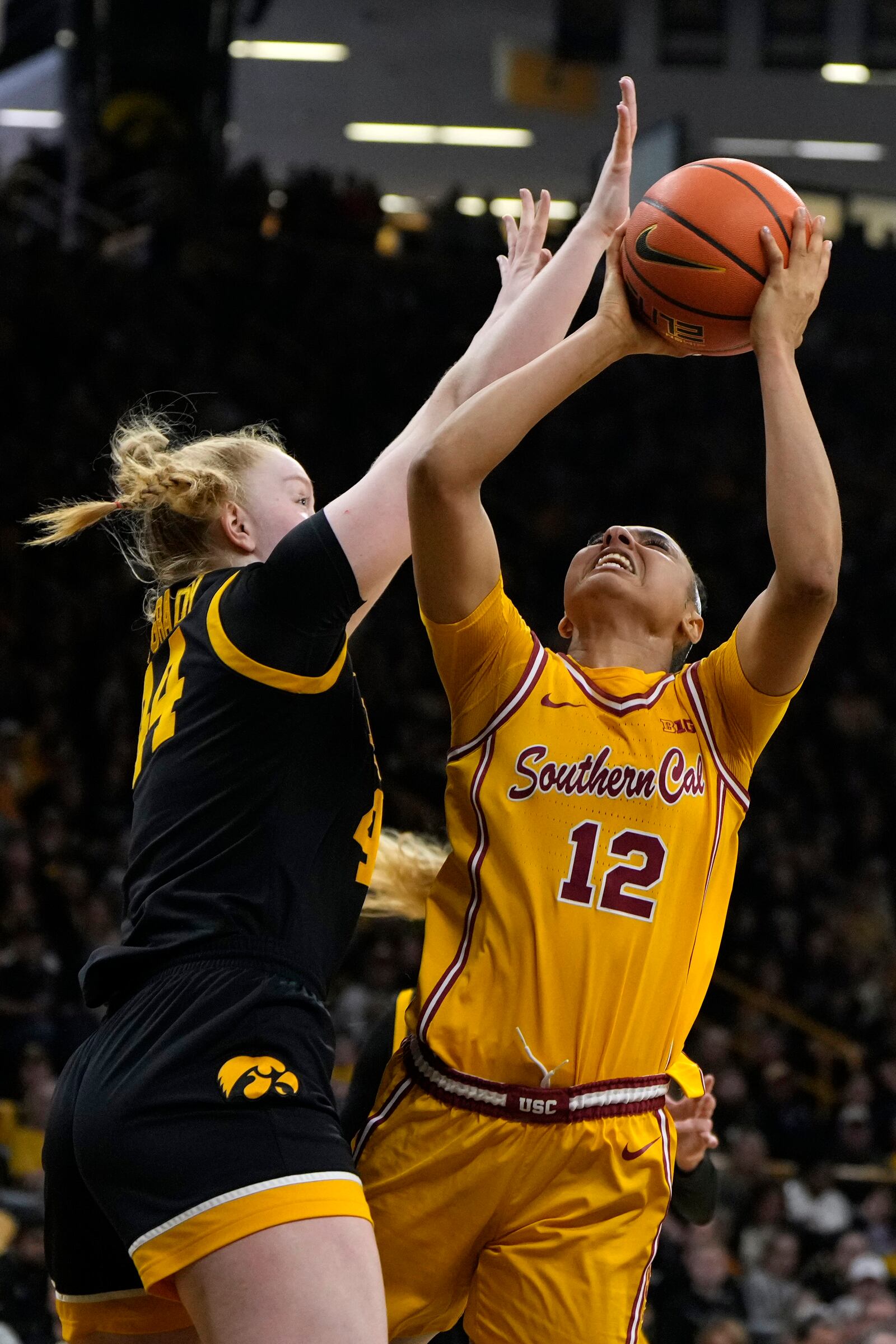 Southern California guard JuJu Watkins (12) shoots over Iowa forward Addison O'Grady, left, during the first half of an NCAA college basketball game, Sunday, Feb. 2, 2025, in Iowa City, Iowa. (AP Photo/Charlie Neibergall)