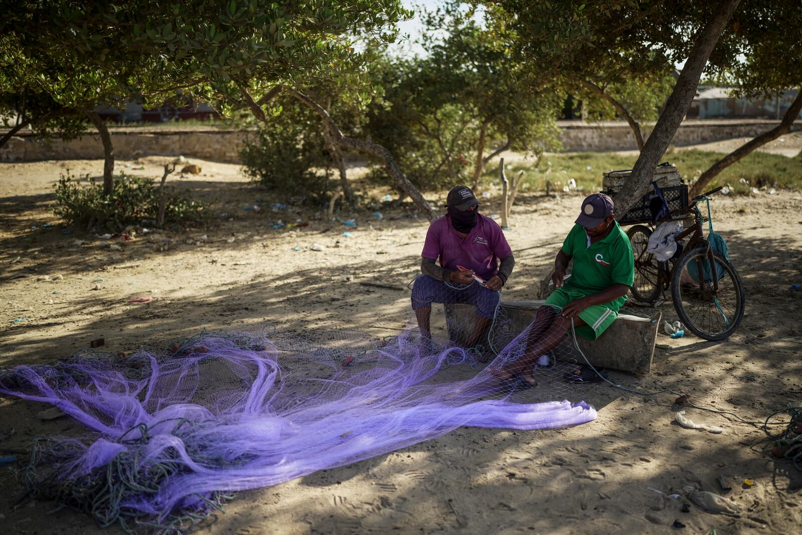 Fishermen weave a net to fish in Manaure, Colombia, Thursday, Feb. 6, 2025. (AP Photo/Ivan Valencia)