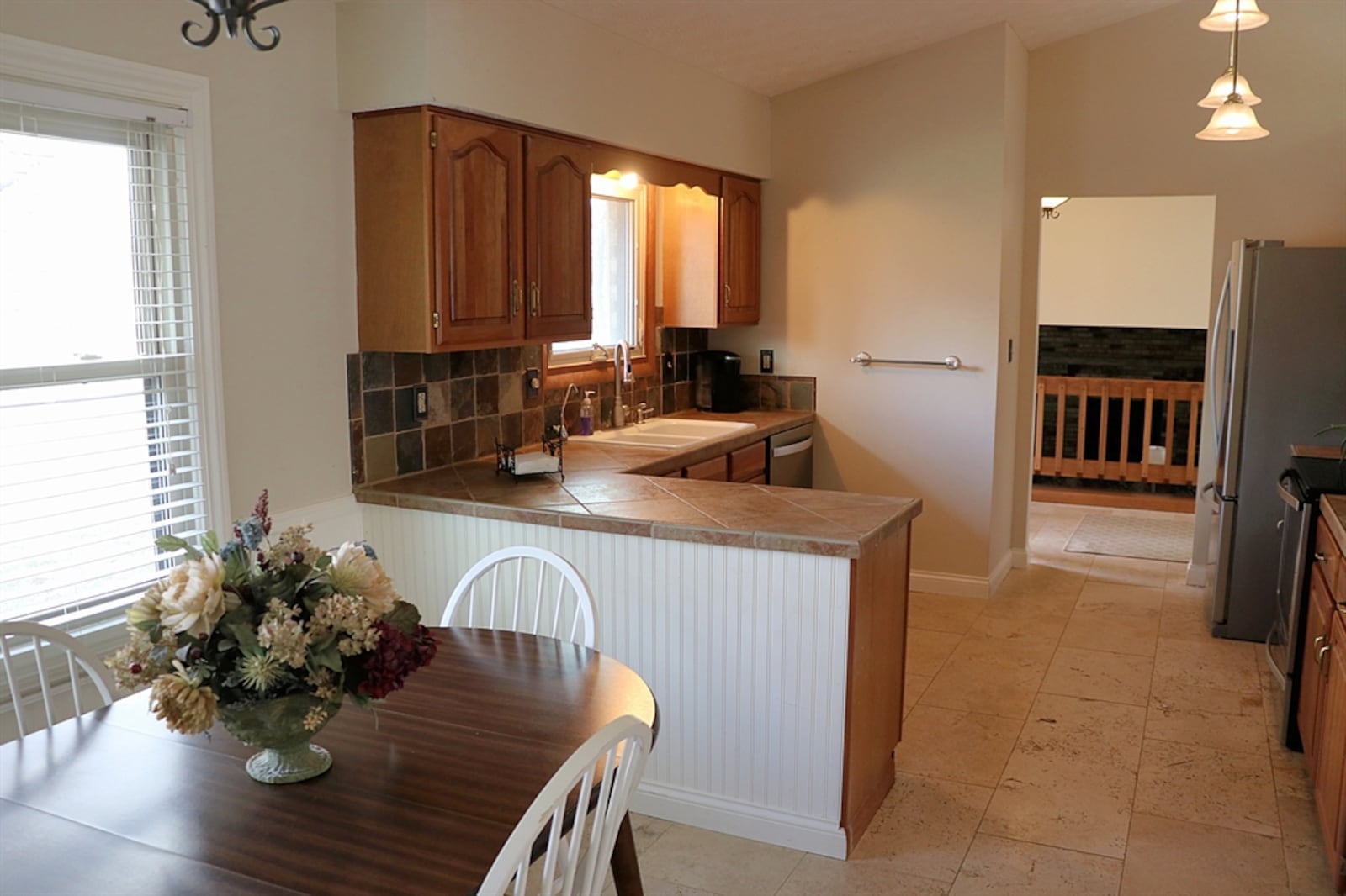 Cabinetry fills two walls of the kitchen, and the light cherry complements the ceramic-tile counters.