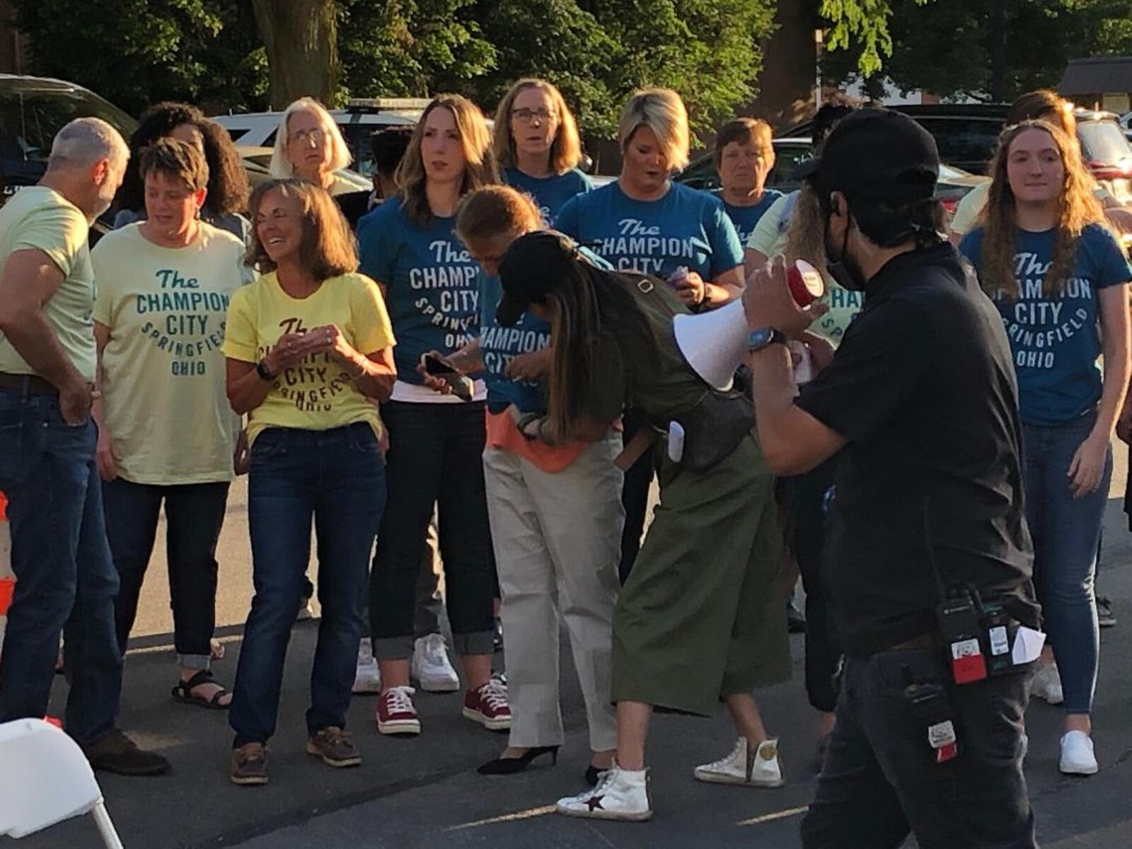 A production crew member gives instructions to the participants of a chorus that supported the featured performers during the filming of the finale of a television pilot in Springfield on Saturday night.