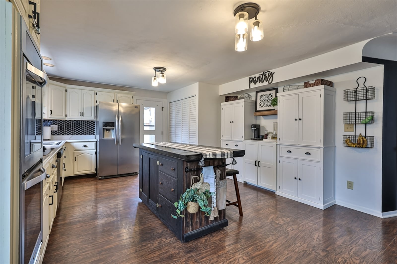 A large island has a slate counter and offers breakfast bar seating for two as well as additional storage. 