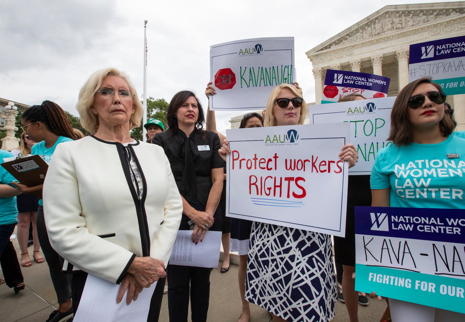 FILE - Lilly Ledbetter, an activist for workplace equality, left, joins demonstrators opposed to President Donald Trump's Supreme Court nominee, Judge Brett Kavanaugh, in front of the Supreme Court, in Washington, Aug. 22, 2018. (AP Photo/J. Scott Applewhite, File)