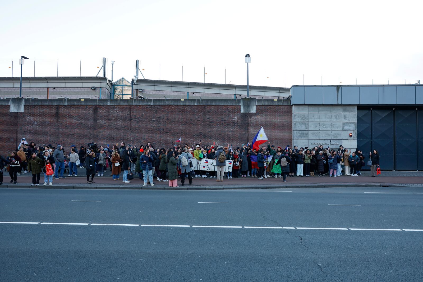 Supporters of former Philippine President Rodrigo Duterte hold flags and banners during a demonstration outside the International Criminal Court detention center near The Hague in Scheveningen, Netherlands, Wednesday, March 12, 2025. (AP Photo/Omar Havana)