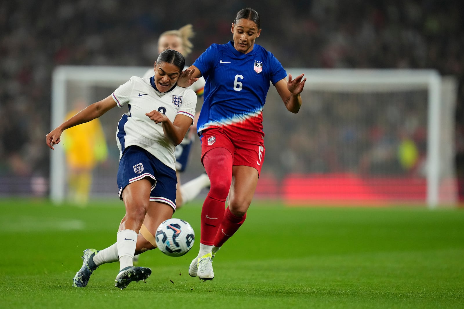 England's Jessica Carter, left, and United States' Lynn Williams challenge for the ball during the International friendly women soccer match between England and United States at Wembley stadium in London, Saturday, Nov. 30, 2024. (AP Photo/Kirsty Wigglesworth)