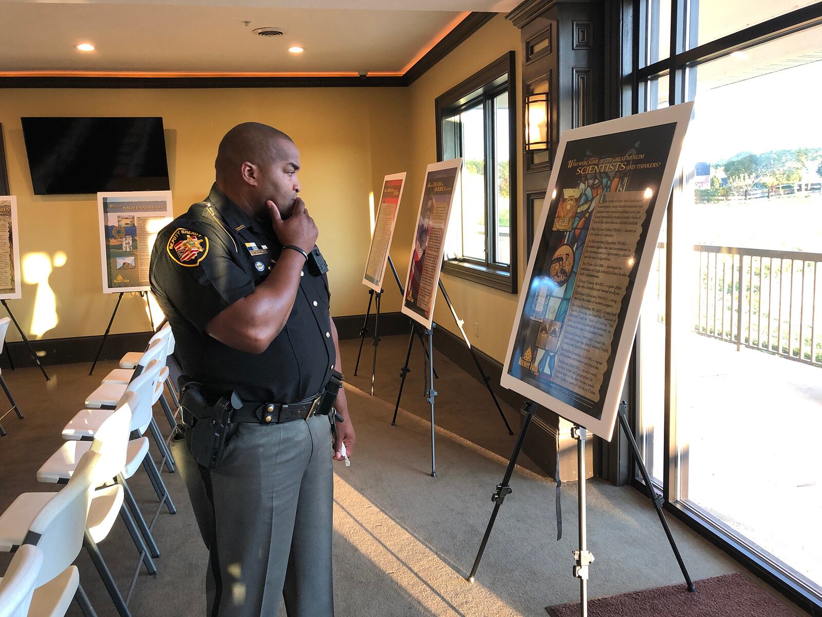 Deputy Matthew Yates checks out one of the posters explaining Islamic values and culture during Springfield's Islamic Day of Ohio event in October 2019. Yates was a recipient of the community heroes awards given that evening. Photo by Brett Turner