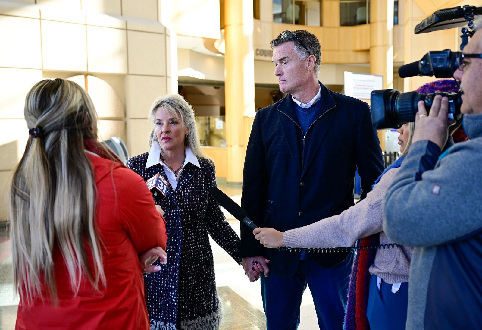 Tamara Dean Harney, left, and her husband, KC Harney, speak to the media at the Jefferson County Government Center after former Colorado Bureau of Investigation scientist Yvonne Woods' first court appearance in Golden, Colo., Thursday, Jan. 23, 2025, in Golden, Colo. (Andy Cross/The Denver Post via AP)