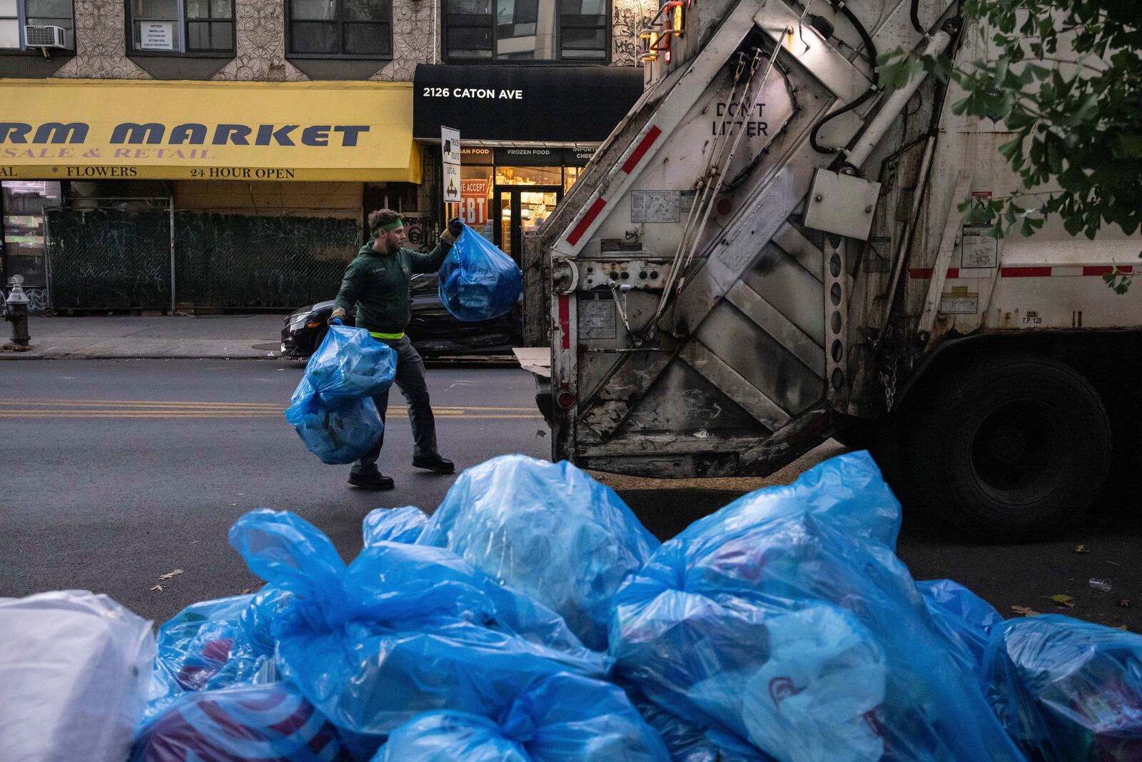 A sanitation worker collects trash, Saturday, Nov. 16, 2024, in the Brooklyn borough of New York. (AP Photo/Yuki Iwamura)