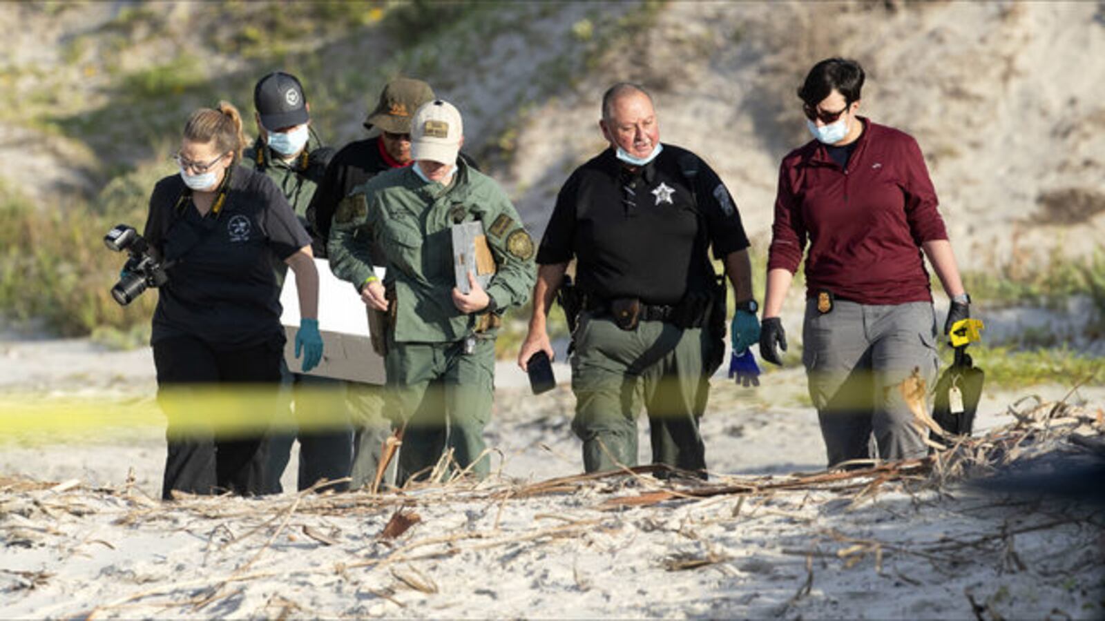 Law enforcement officers comb the area where James Butler, 48, and his wife, Michelle Butler, 45, were found buried Oct. 27, 2019, on Padre Island, Texas. Adam Curtis Williams, 33, is wanted in connection with the New Hampshire couple's deaths.