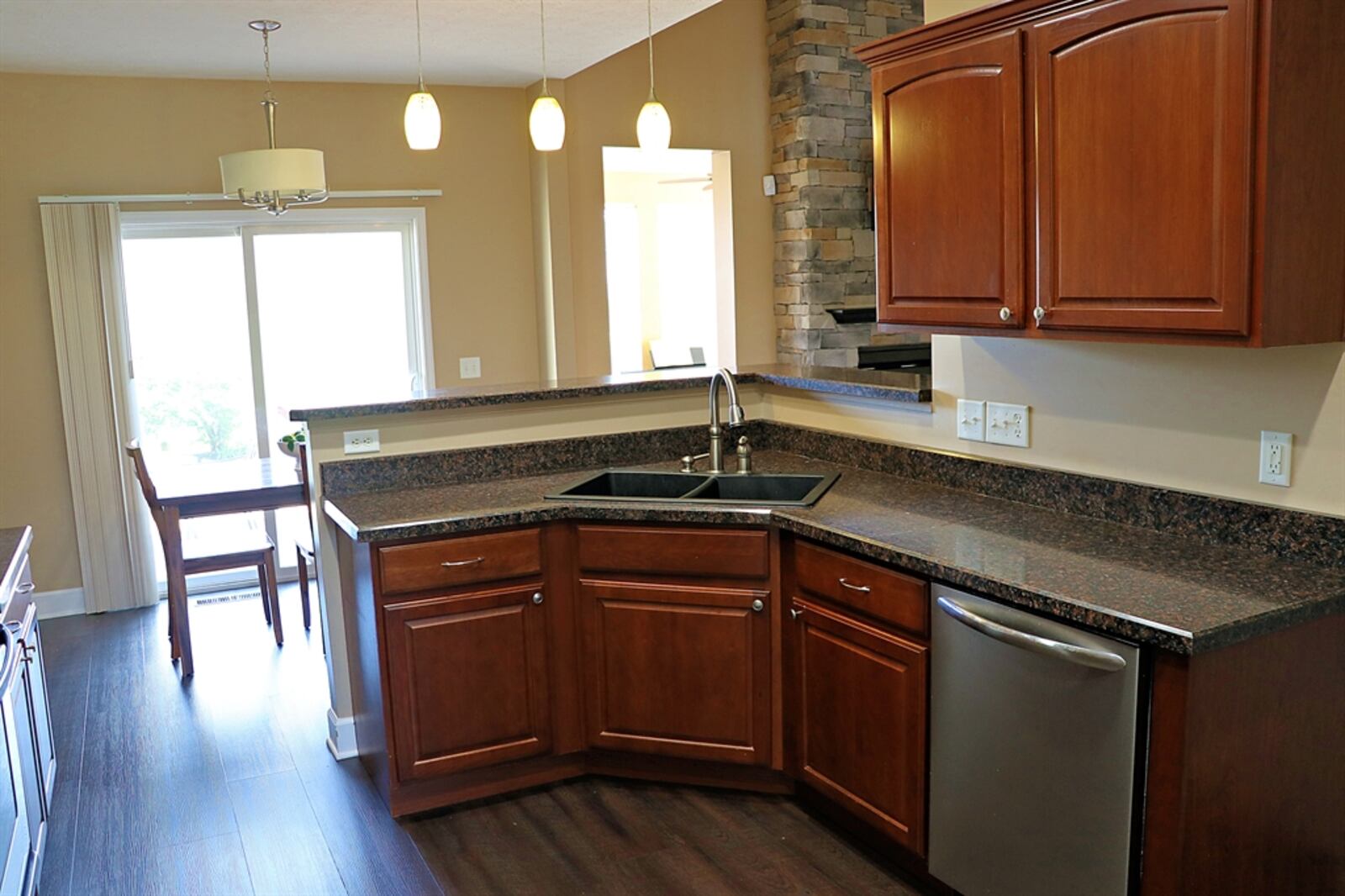 Open to the great room and separated by a two-level peninsula counter, the kitchen and breakfast room has wood-laminate flooring.