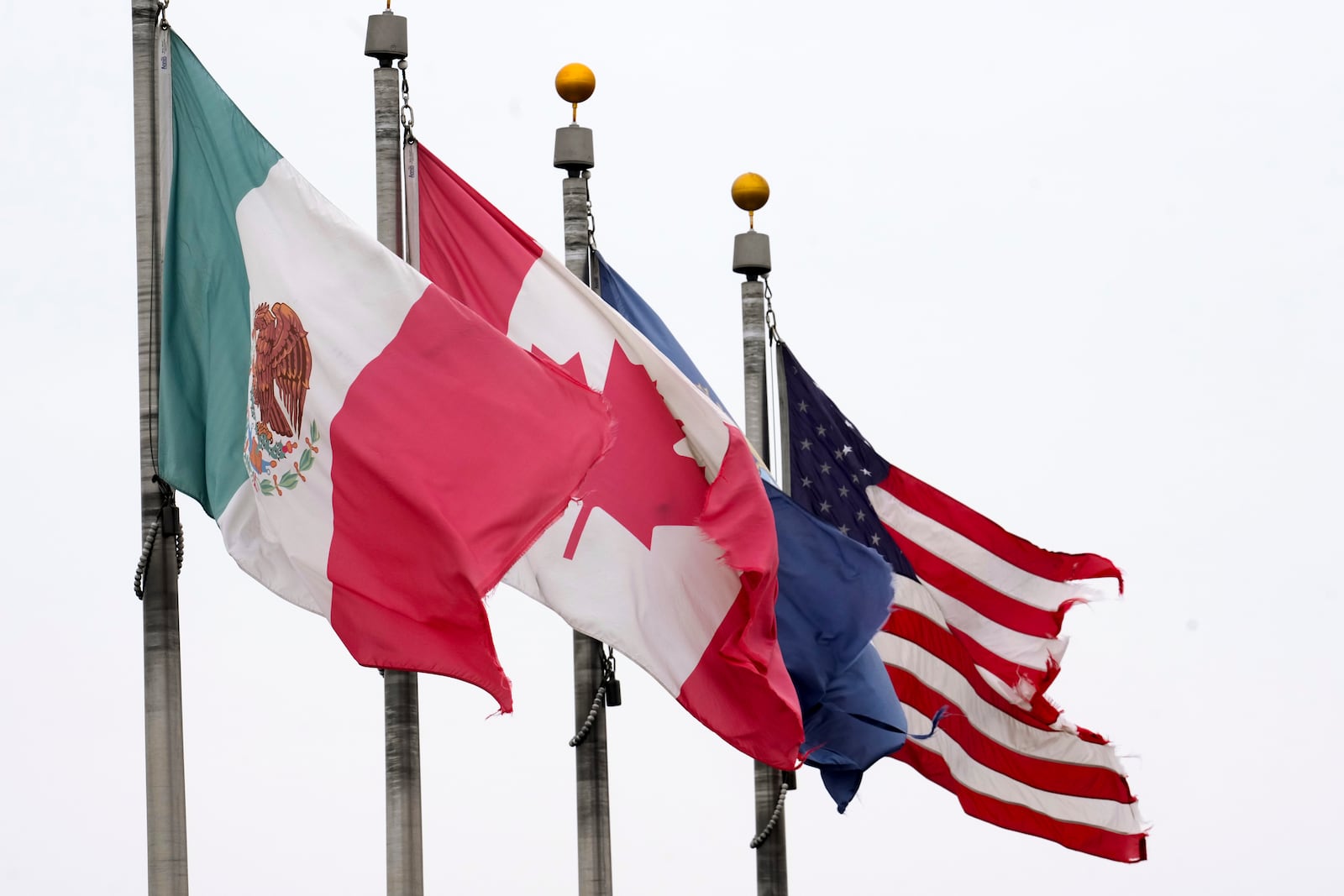 FILE - The flags of Mexico, Canada and the United States are shown near the Ambassador Bridge, Monday, Feb. 3, 2025, in Detroit. (AP Photo/Paul Sancya, File)