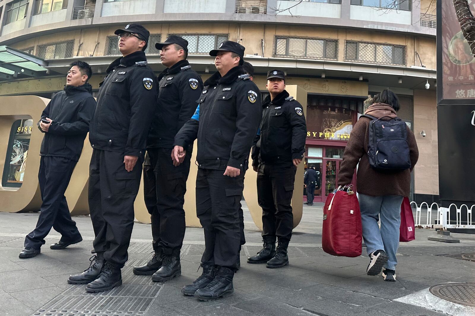 Chinese security personnel patrol the street near a meeting of family members of passengers who were on board the MH370 Malaysia Airline jet that went missing in 2014 in Beijing, China, Saturday, March 8, 2025. (AP Photo/Ng Han Guan)