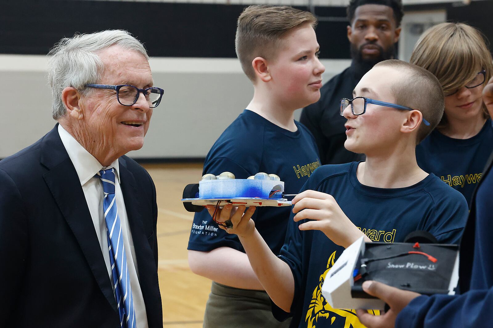 Joe Kelly, a member of the Hayward Middle School drone soccer team, shows the battle bot he made to Gov. Mike DeWine on Tuesday, May 7, 2024, during the governor's visit to the school in Springfield. The drone soccer team recently returned from Washington, D.C., where they competed in the National Drone Soccer Championships. Hayward was the first school in Ohio to have a drone soccer team. BILL LACKEY/STAFF