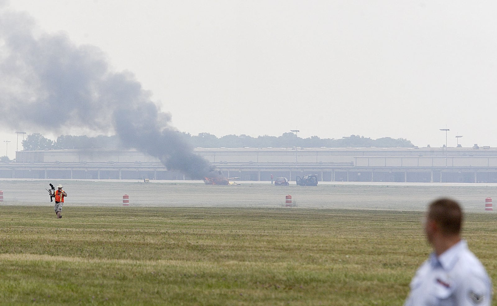 People on the ground watch as Jim Leroy's plane burns following his crash at the Vectren Dayton Air Show, Saturday, July 28, 2007.