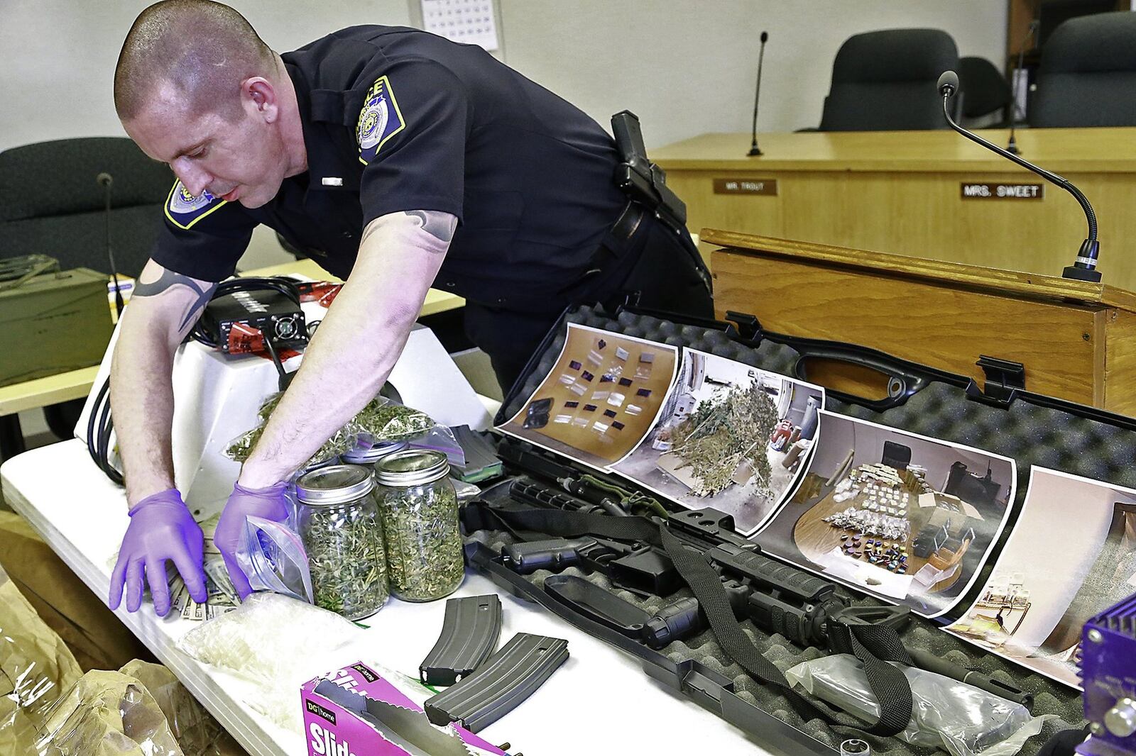 Lt. Mike Holler, of the Emon Police Department, displays some of the drugs and money that was siezed during a drug bust. Bill Lackey/Staff