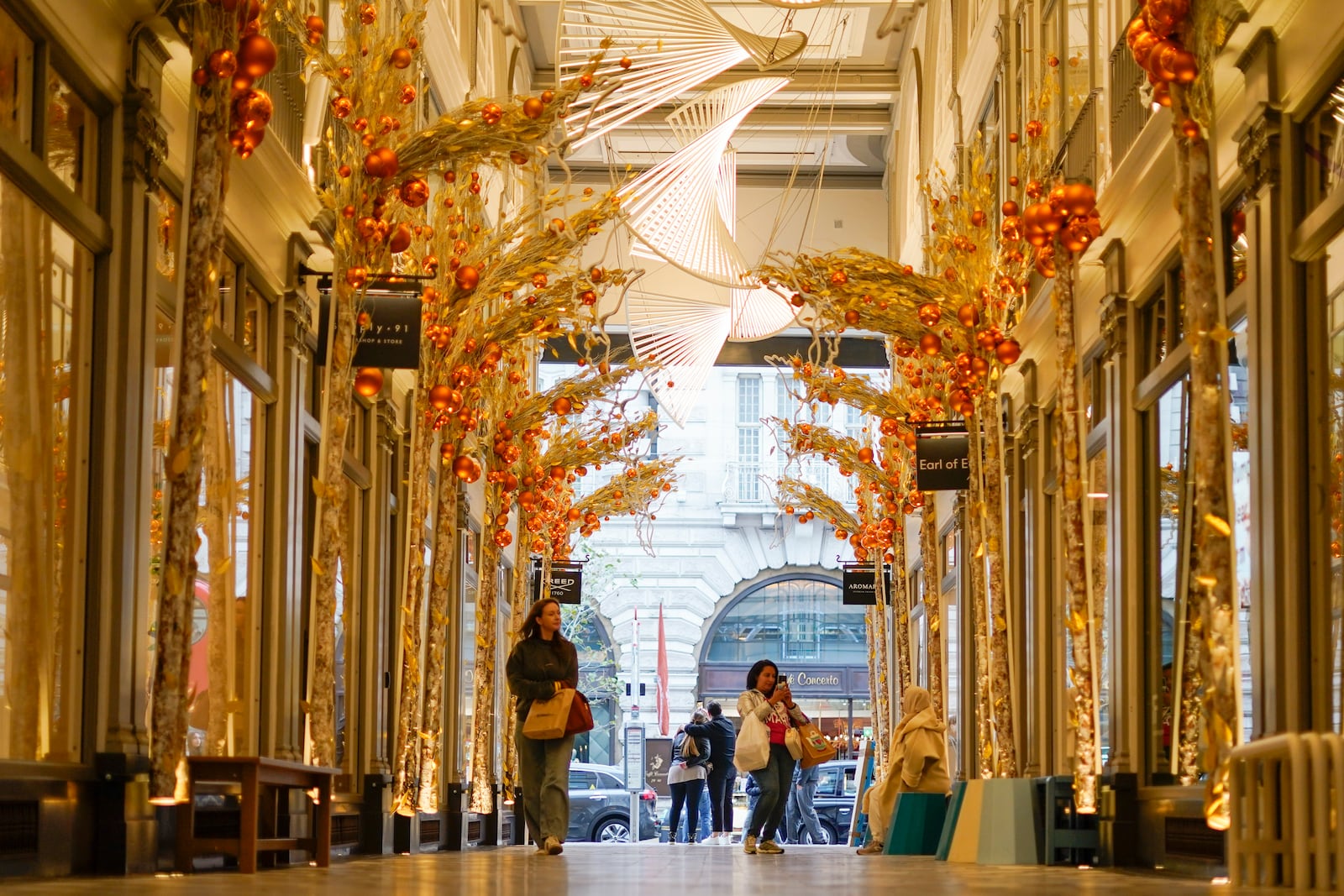 FILE - People walk in a decorated arcade near Piccadilly Circus in London, Oct. 31, 2024. (AP Photo/Alberto Pezzali, File)