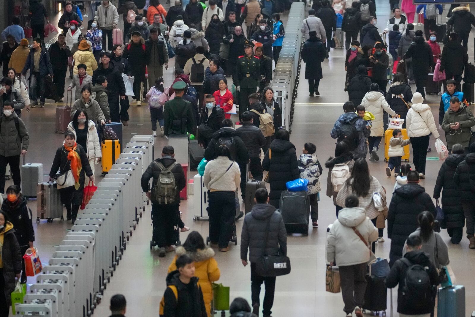 Travelers rush at the departure hall to catch their trains at the Beijing West Railway Station ahead of the Lunar New Year in Beijing on Friday, Jan. 24, 2025. (AP Photo/Aaron Favila)