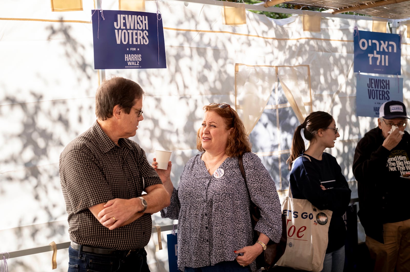 Mark and Suzan Lopatin gather with other supportes of Democratic presidential nominee Vice President Kamala Harris in a Sukkot before going door to door to canvass Jewish voters Sunday, Oct. 20, 2024. (AP Photo/Laurence Kesterson)