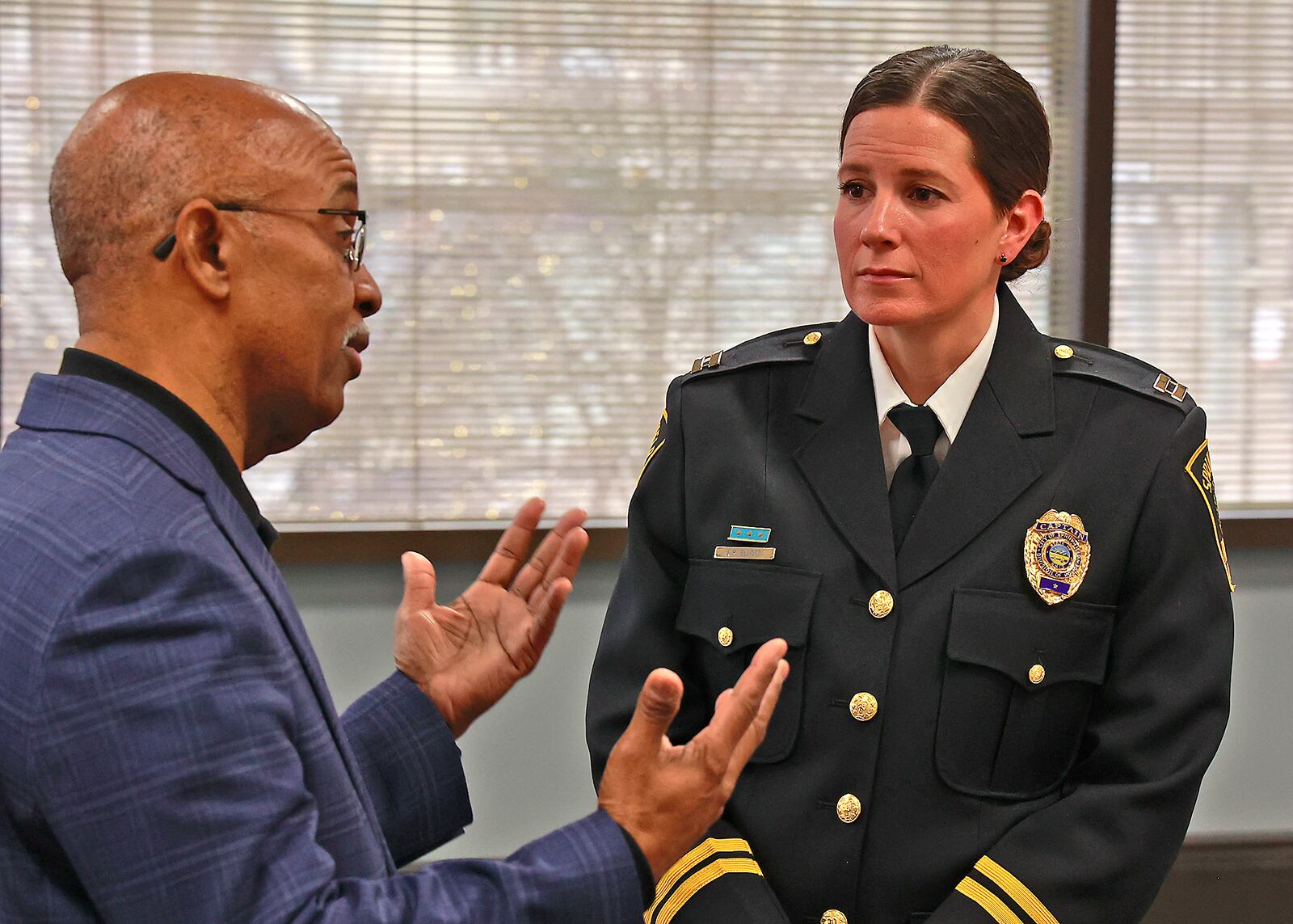 Capt. Allison Elliott, the new Springfield Police Chief, talks with James Bacon, chairman of the Community Police Advisory Team, following a press conference announcing her appointment Monday, Dec. 19, 2022. BILL LACKEY/STAFF