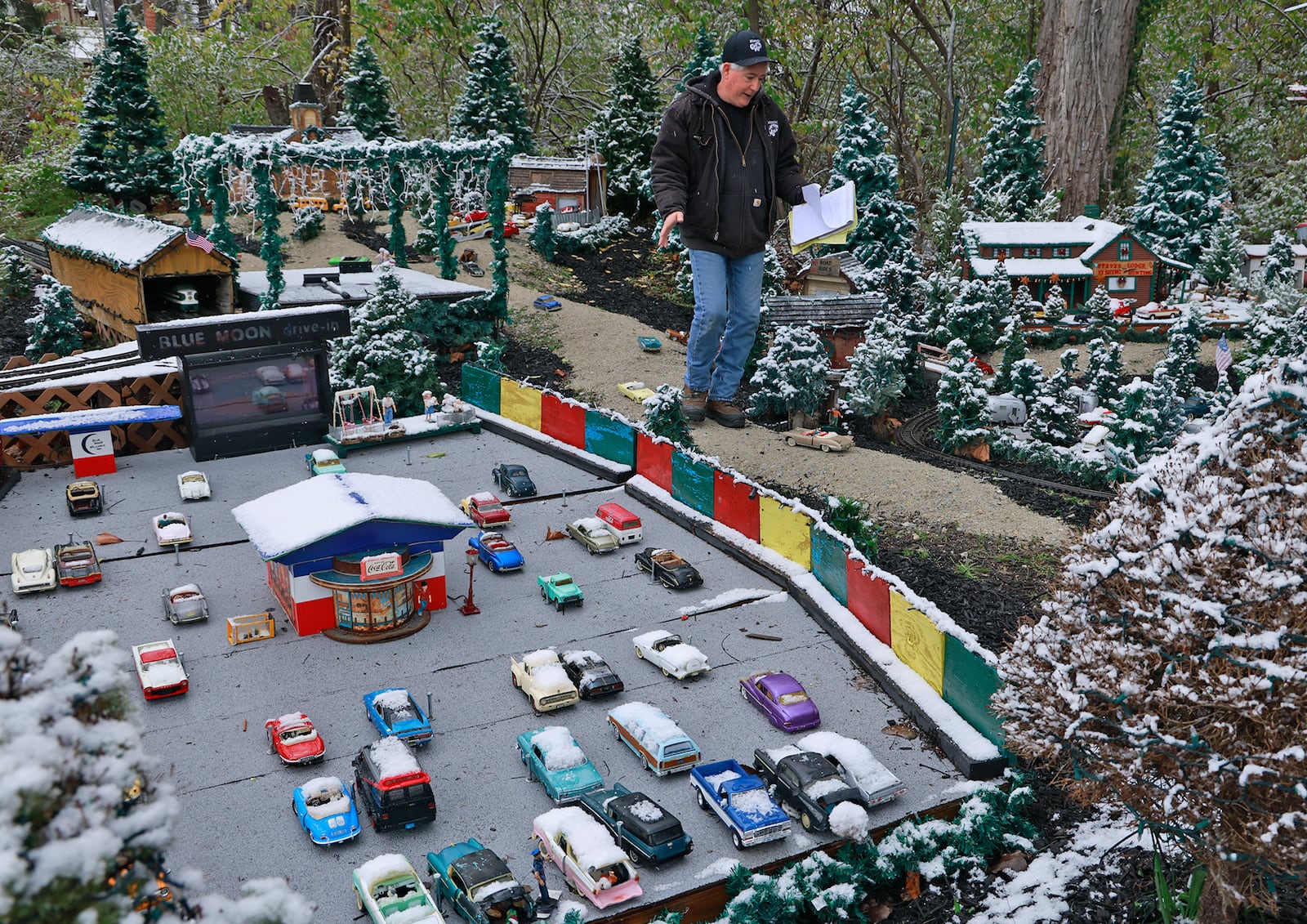 Anthony Satariano, who owns the Historic Clifton Mill with his mom, Pat, checks on the miniature village before opening night of the holiday lights. BILL LACKEY/STAFF