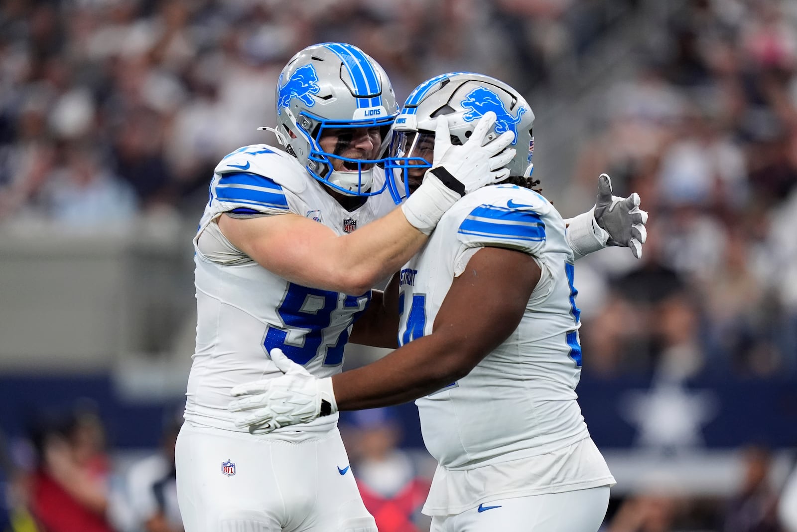 Detroit Lions defensive end Aidan Hutchinson (97) and Alim McNeill, right, celebrate after McNeill sacked Dallas Cowboys' Dak Prescott (4) in the first half of an NFL football game in Arlington, Texas, Sunday, Oct. 13, 2024. (AP Photo/LM Otero)