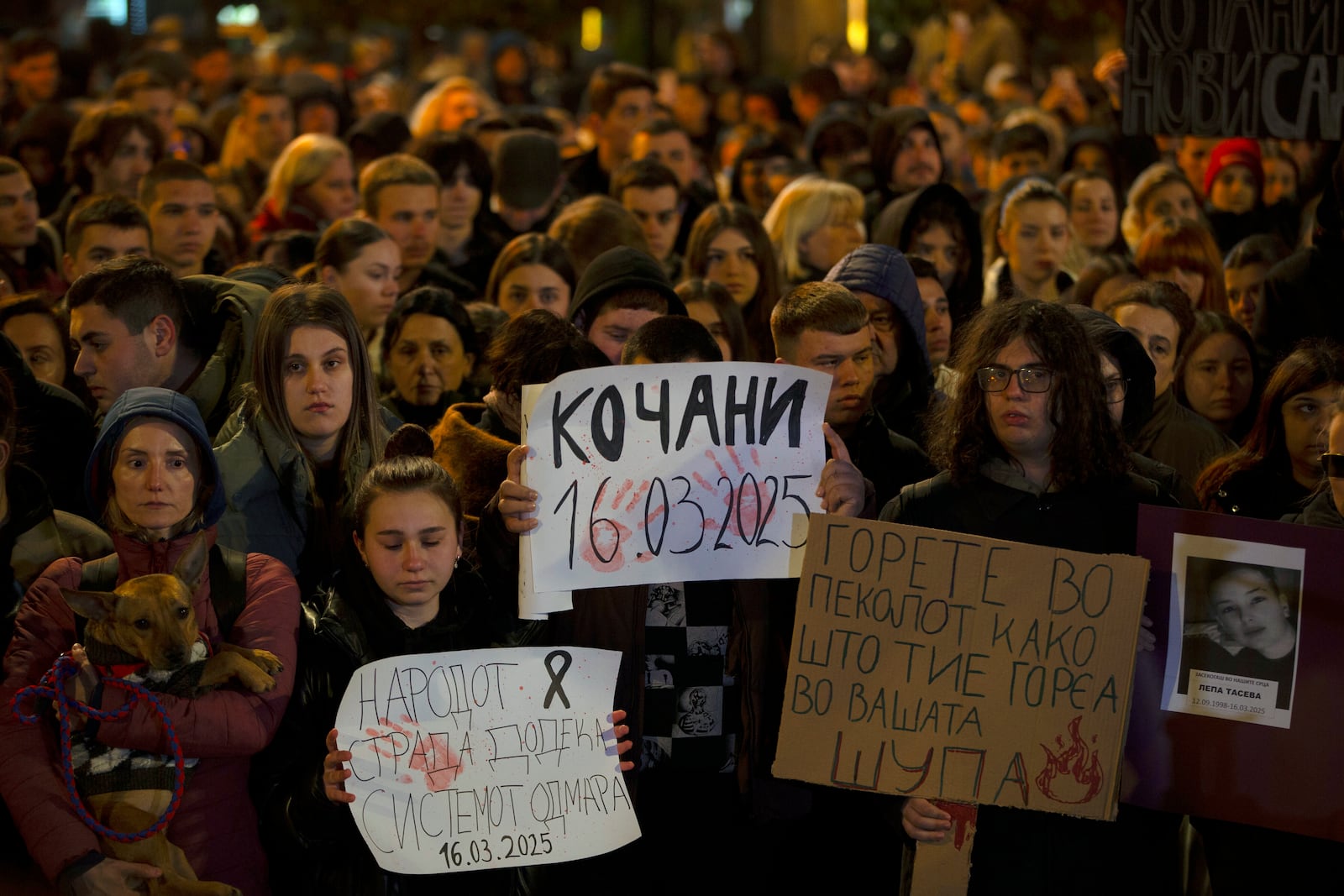 Protesters hold placards as thousands gather in protest for the victims of a massive nightclub fire in the town of Kocani, in Skopje, North Macedonia, Tuesday, March 18, 2025. (AP Photo/Visar Kryeziu)