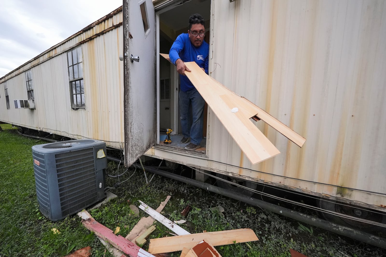 Mario Mendoza works on repairing a mobile home in Belle Chasse, La., Wednesday, Jan. 15, 2025, that was damaged from Hurricane Ida in 2021. (AP Photo/Gerald Herbert)