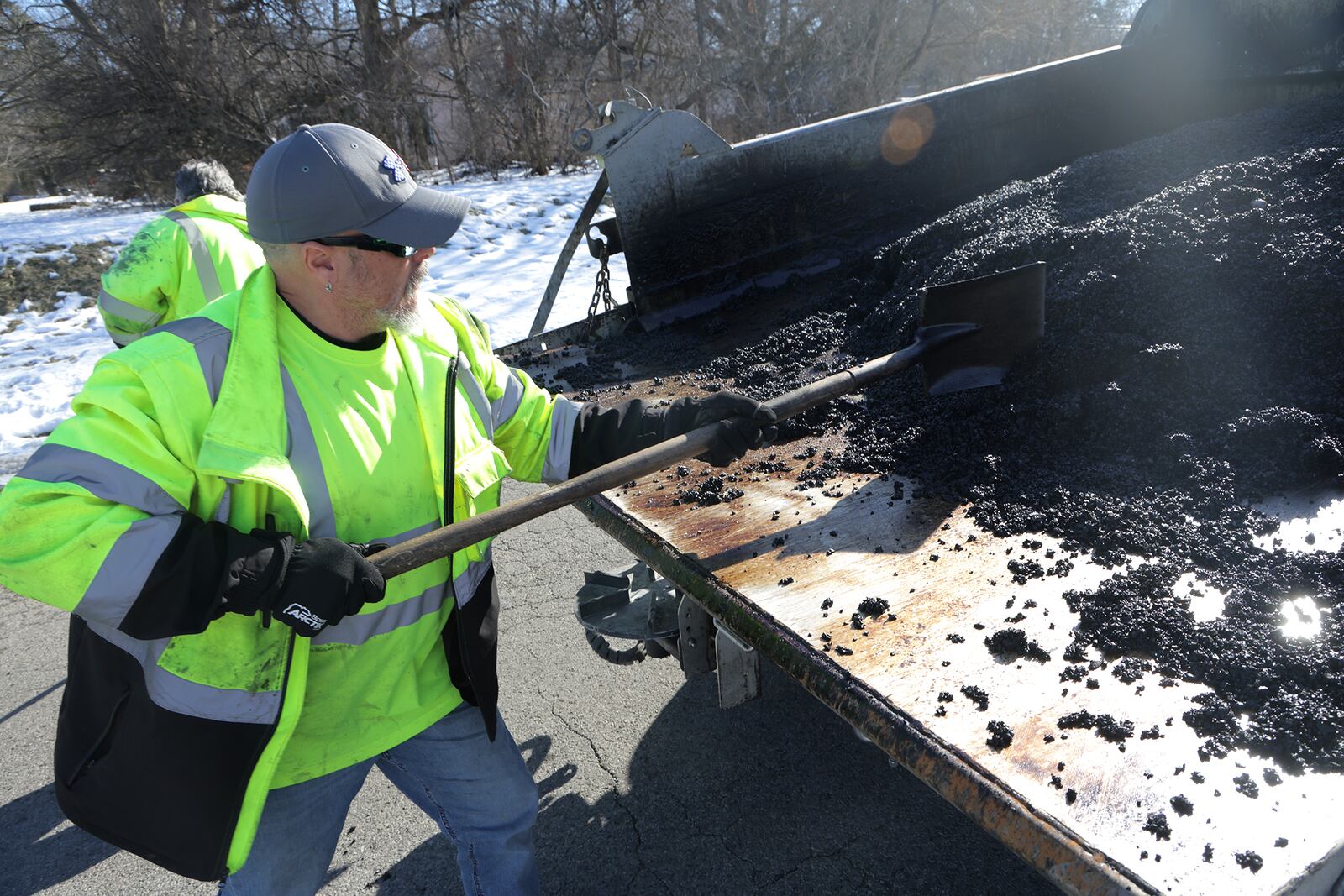 Tait Schnitzler, an employee of the City of Springfield, patches a pot hole along Superior Avenue Tuesday, Jan. 28, 2025. BILL LACKEY/STAFF