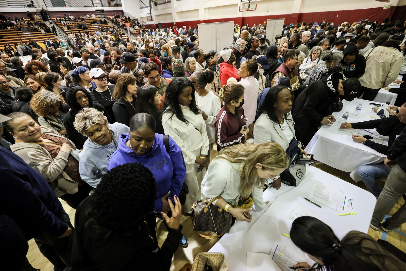 People impacted by the Eaton Fire wait in line to receive a check at the gymnasium of Pasadena City College where The Change Reaction is handing out about 1,000 checks of between $2,500-$5,000, Tuesday, Jan. 28, 2025 in Pasadena, Calif. (AP Photo/Etienne Laurent)