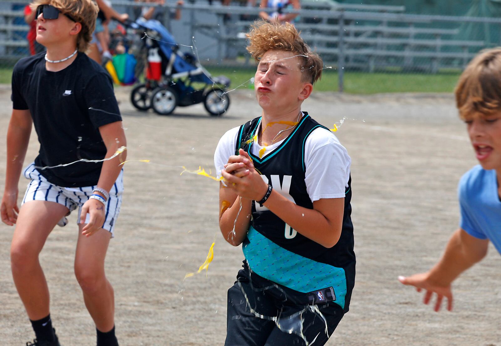 Elijah Filio, 13, grimaces as an egg explodes in his hands Wednesday, August 9, 2023 during the egg toss event at the Champaign County Fair Youth Day activities. BILL LACKEY/STAFF